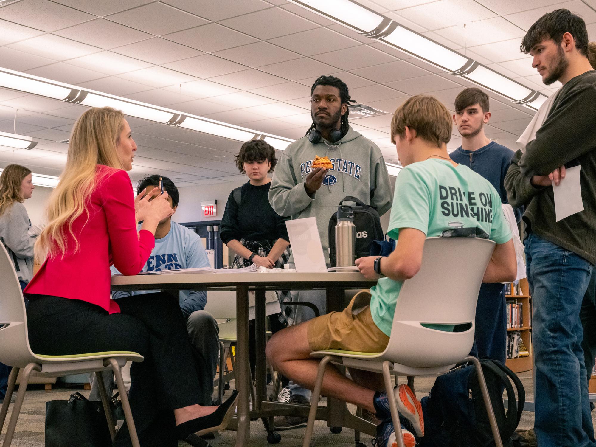A group of students listen to Erin Weber during a roundtable session.