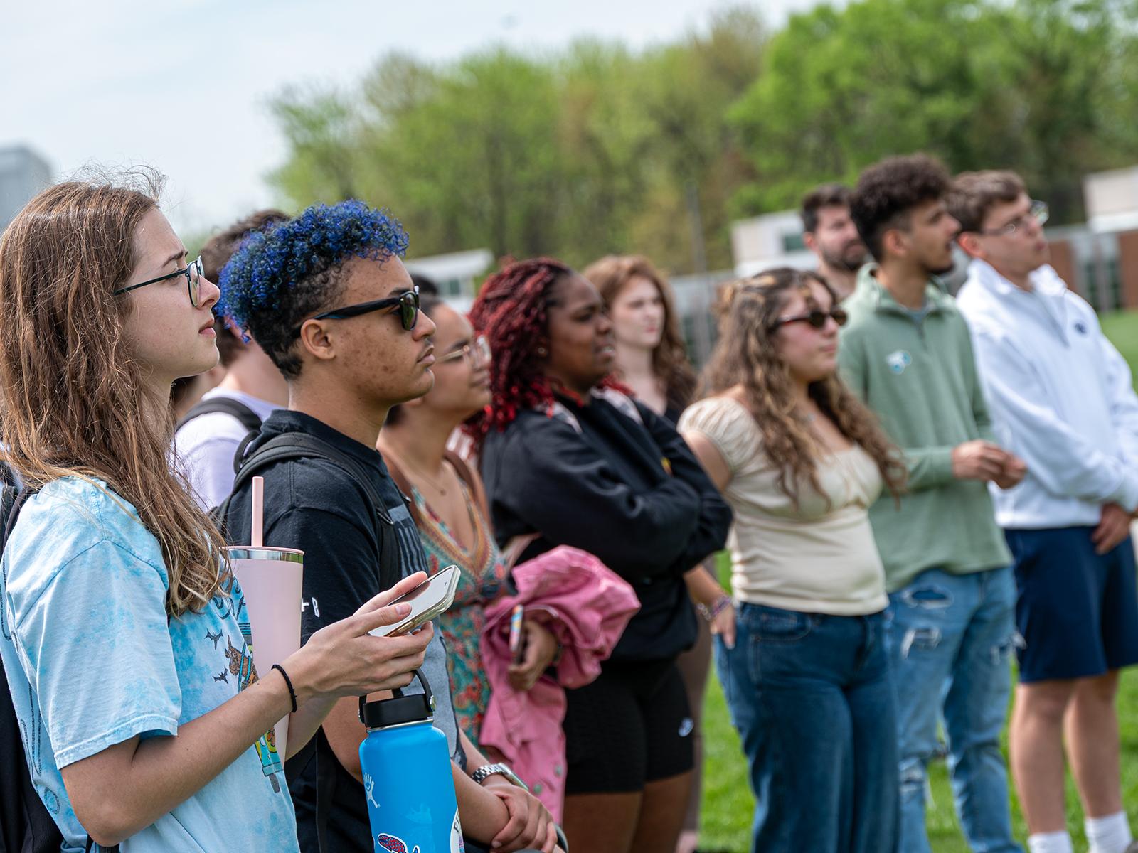 A crowd of students watch a groundbreaking ceremony