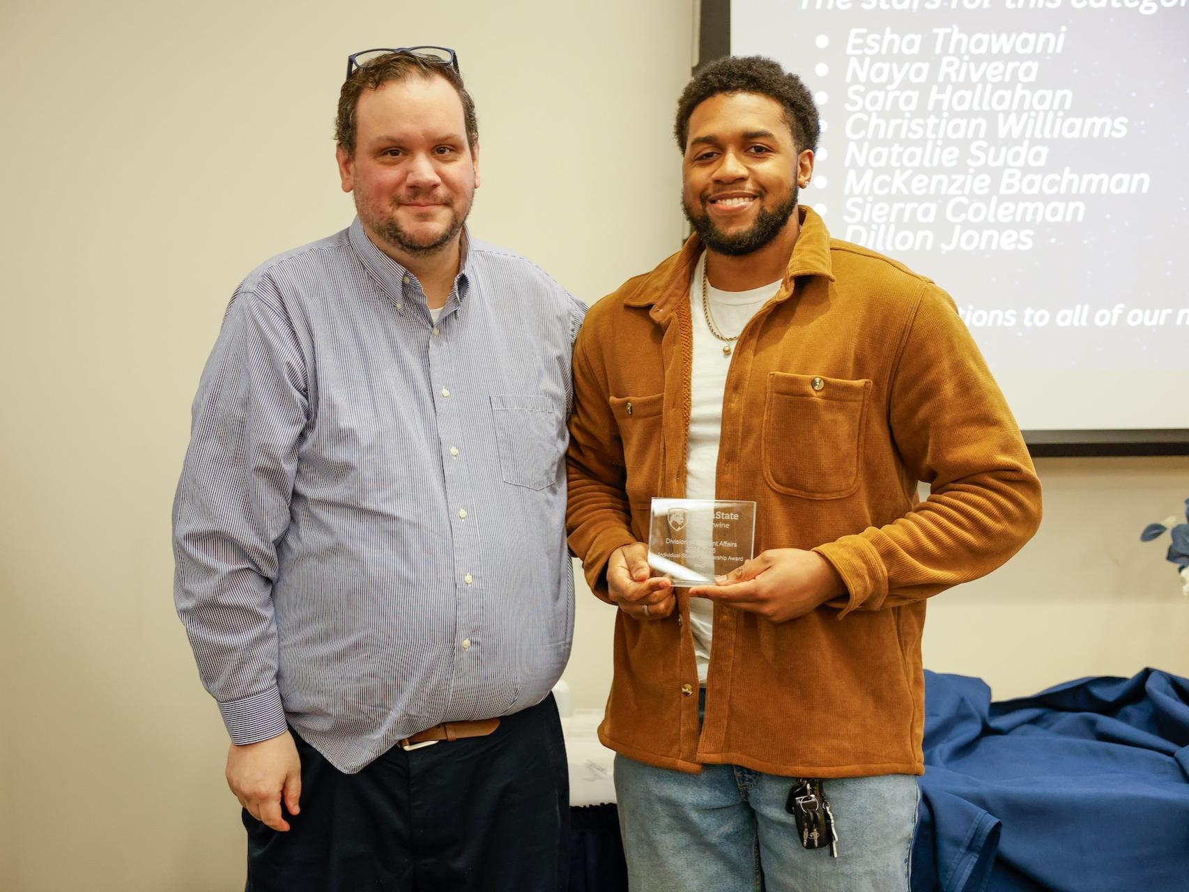 student with award and staff member