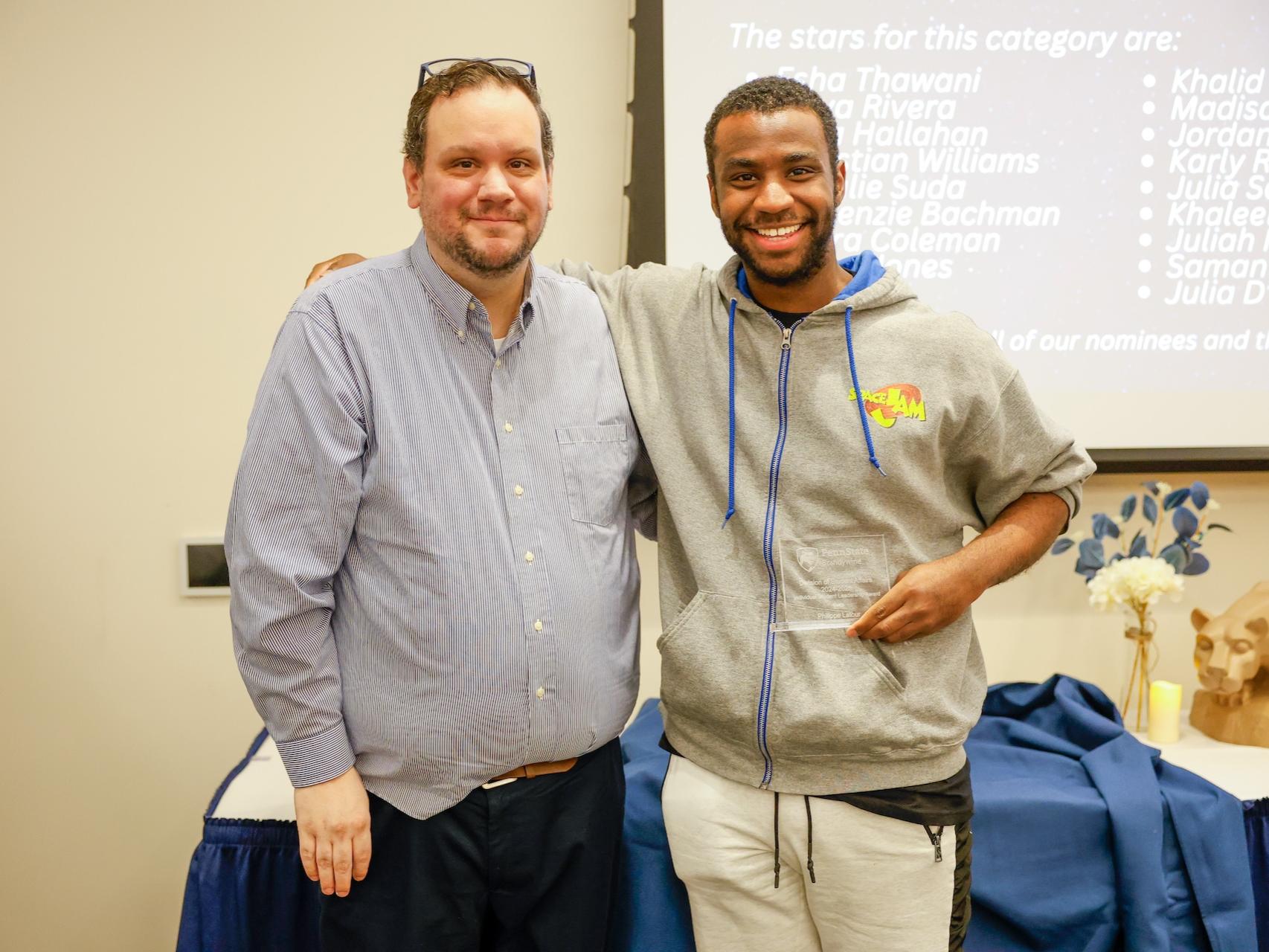 student and staff member with award