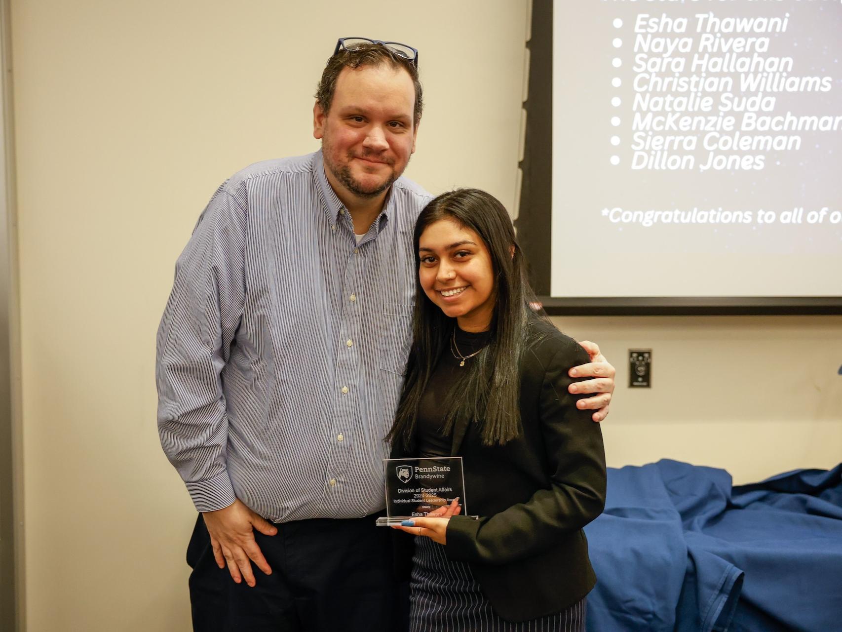 student and staff member with award