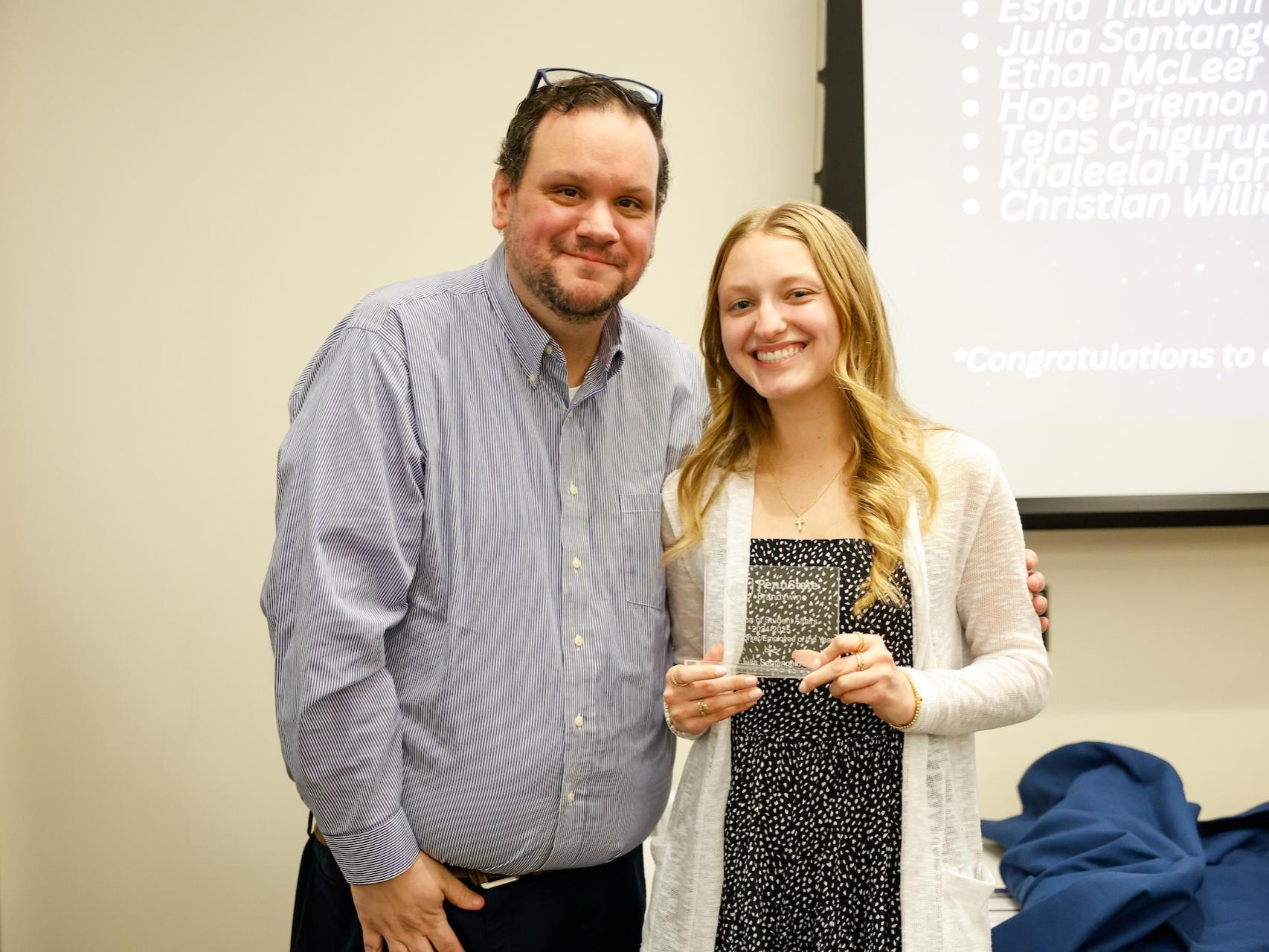 student and staff member with award