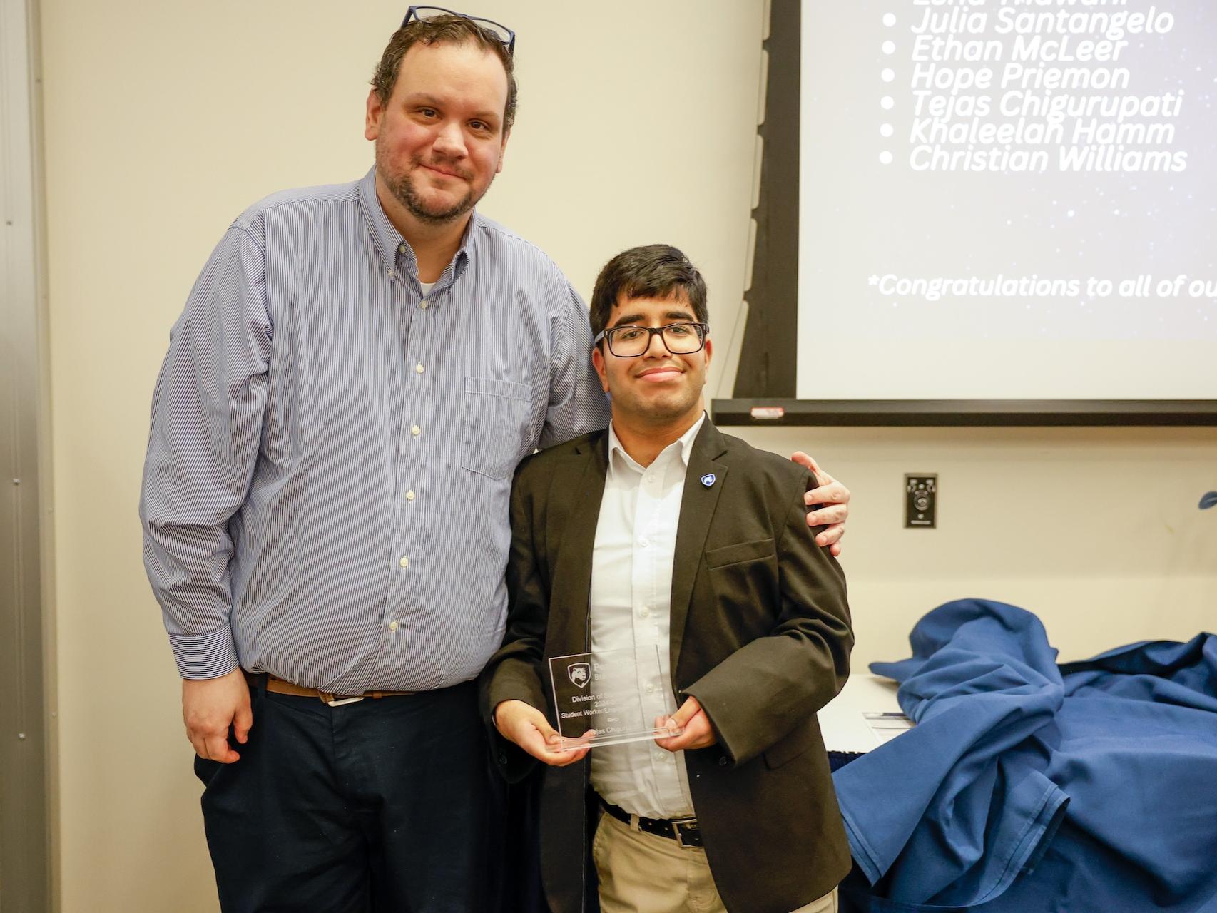 student and staff member with award