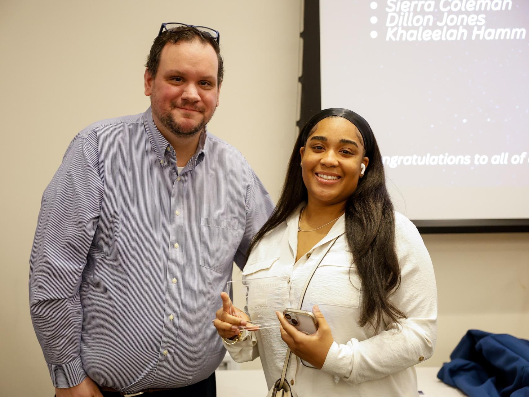 student and staff member with award
