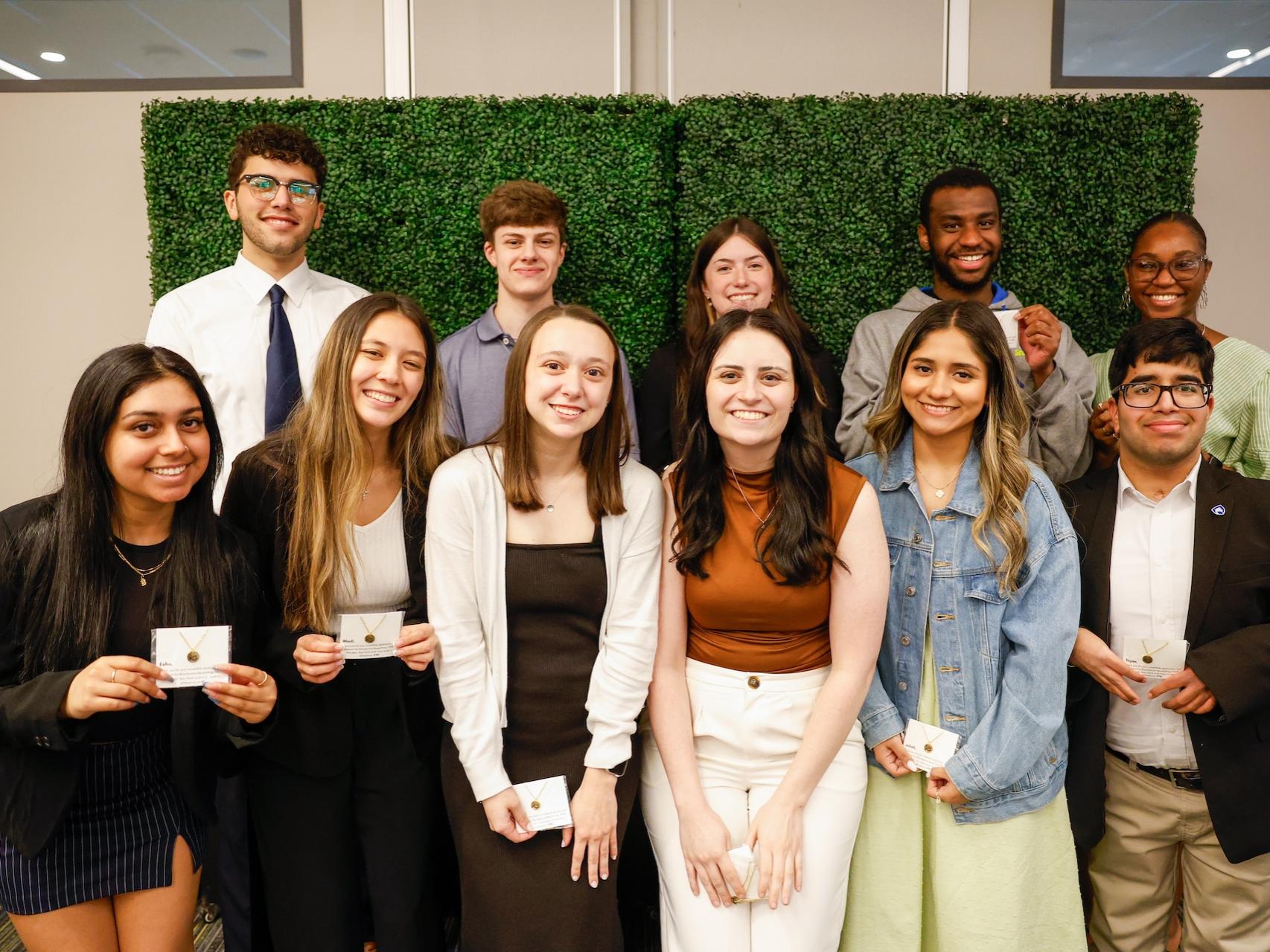 group of students holding necklaces