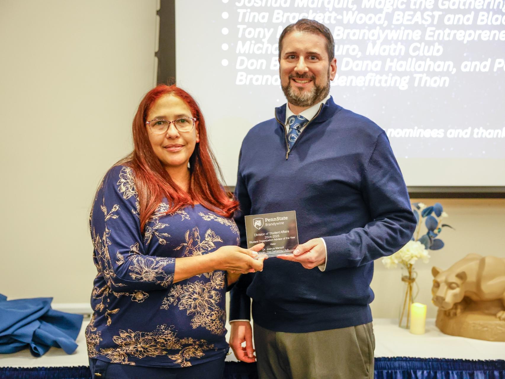 two people holding an award
