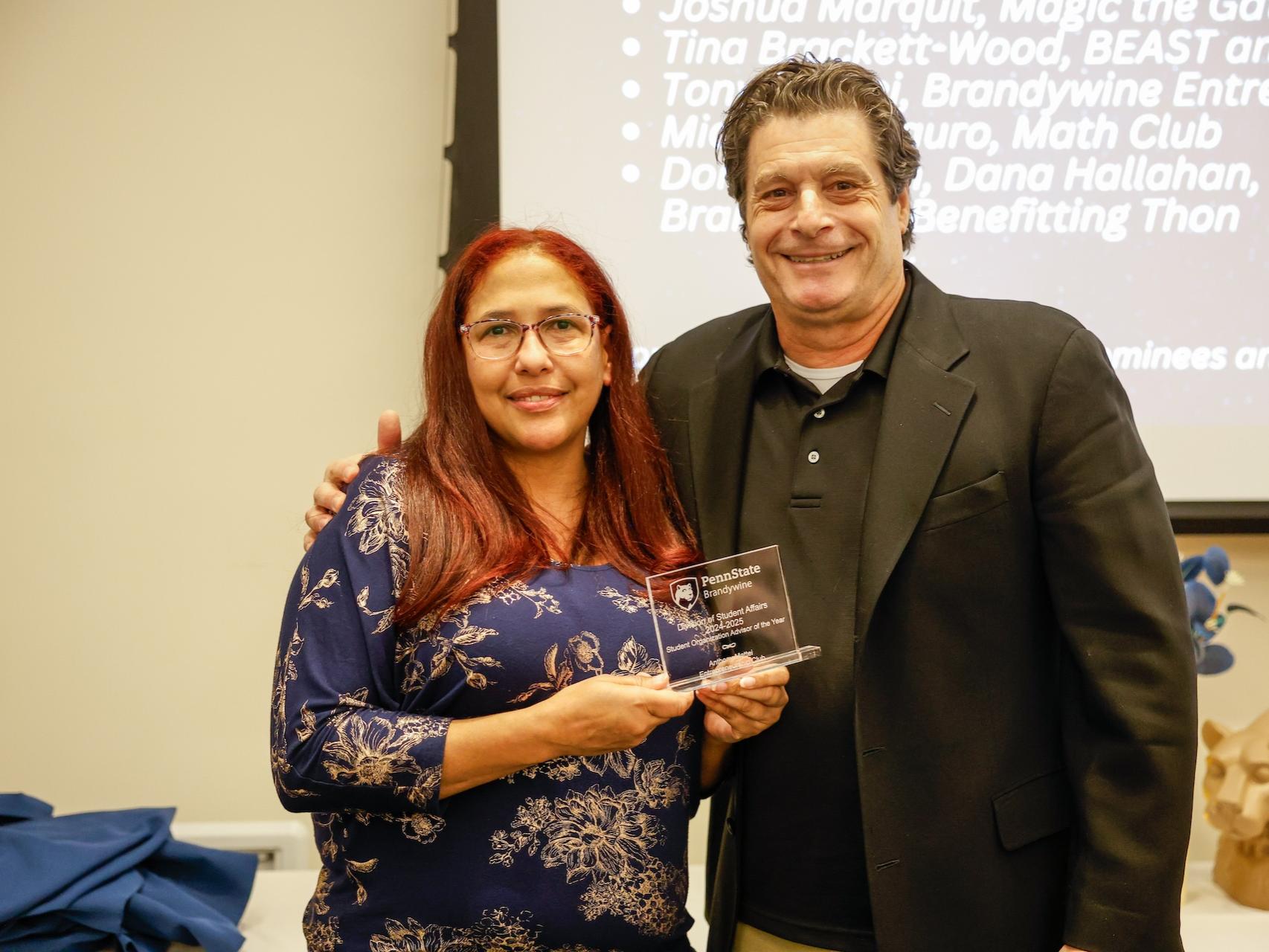 two people holding an award