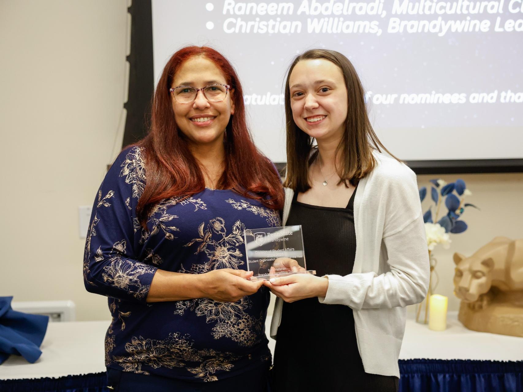 student and staff member with award