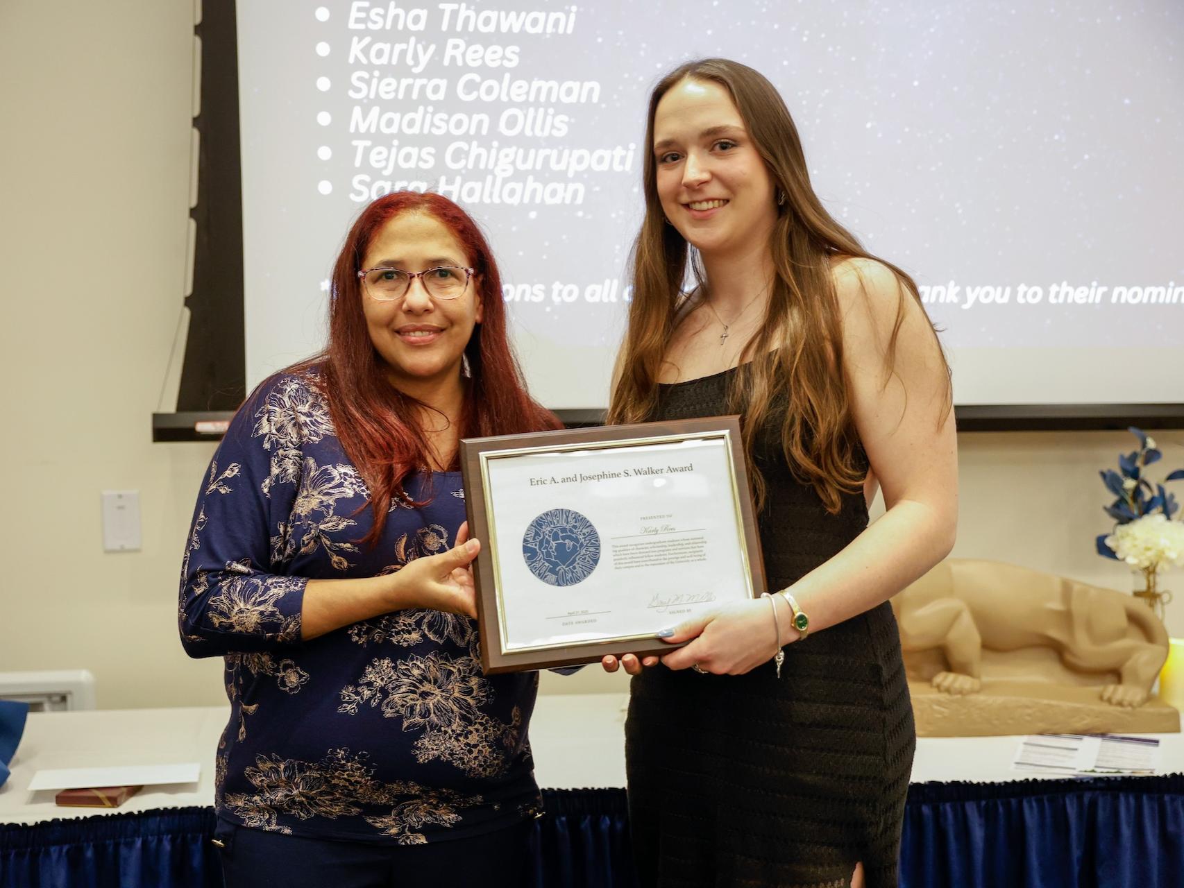 student and staff member with award