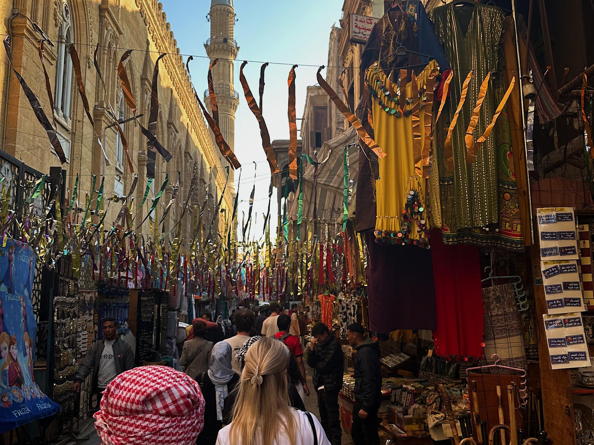 People walking through the crowded city of Cairo, Egypt, with the streets decorated with streamers for Ramadan.