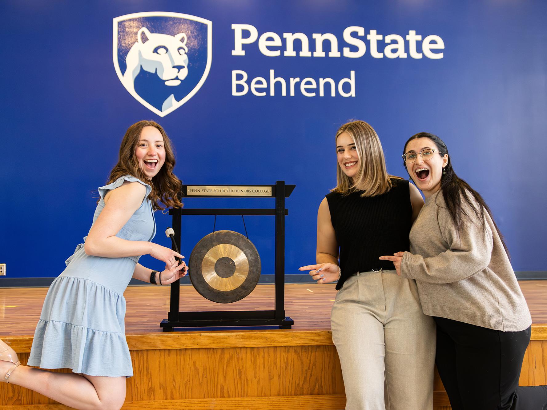 A group of Scholars stand in front of the gong at PSU Behrend