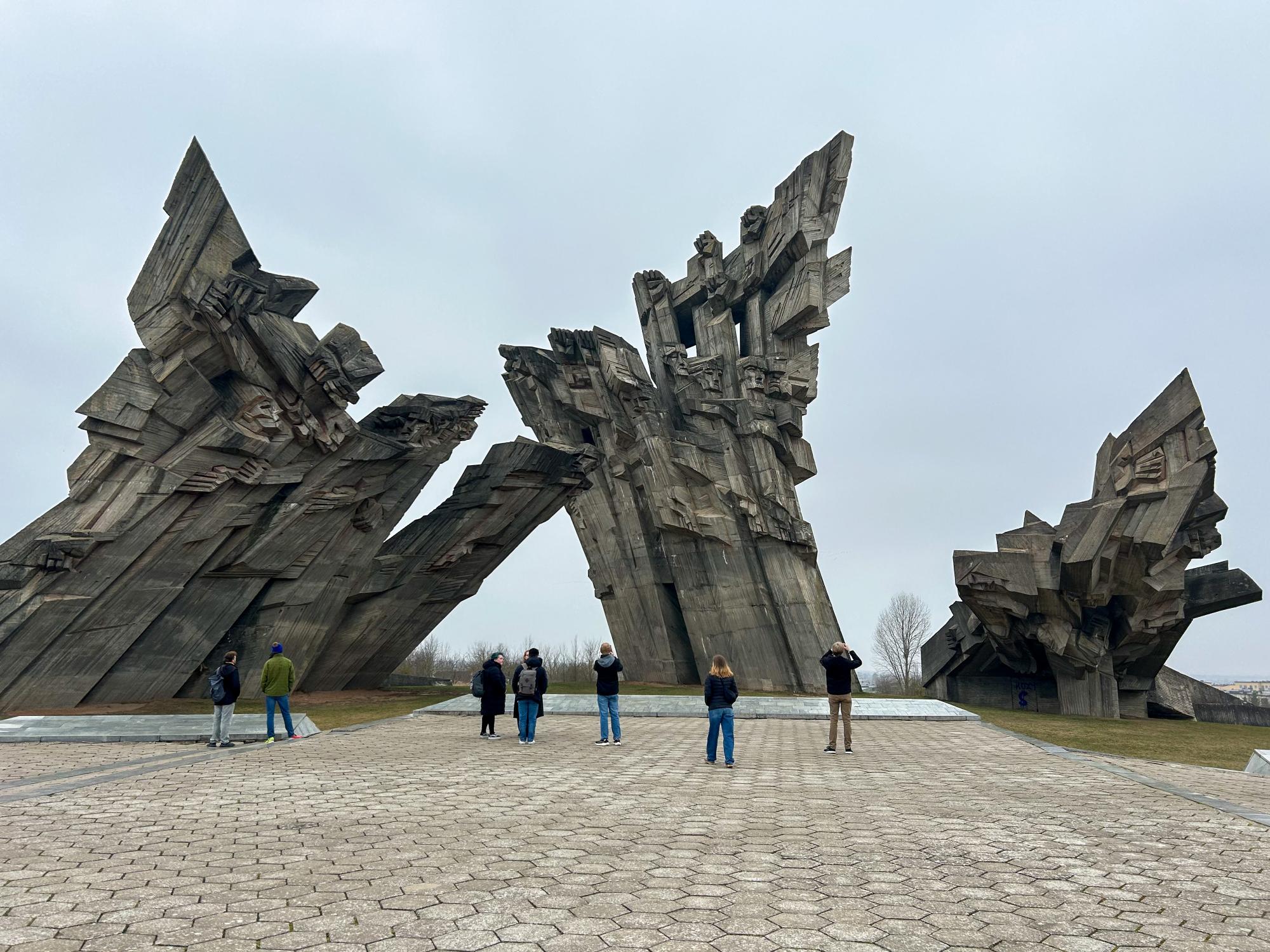 Students stand in front of a memorial at the Ninth Fort in Kaunas, Lithuania.