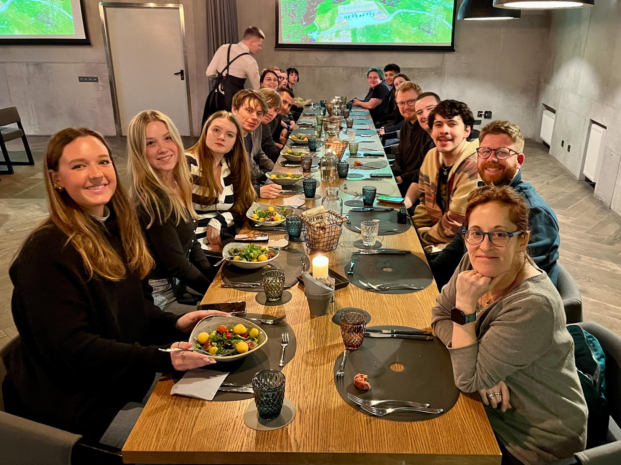 Students sit at a long table in a restaurant during their farewell dinner in Vilnius, Lithuania.