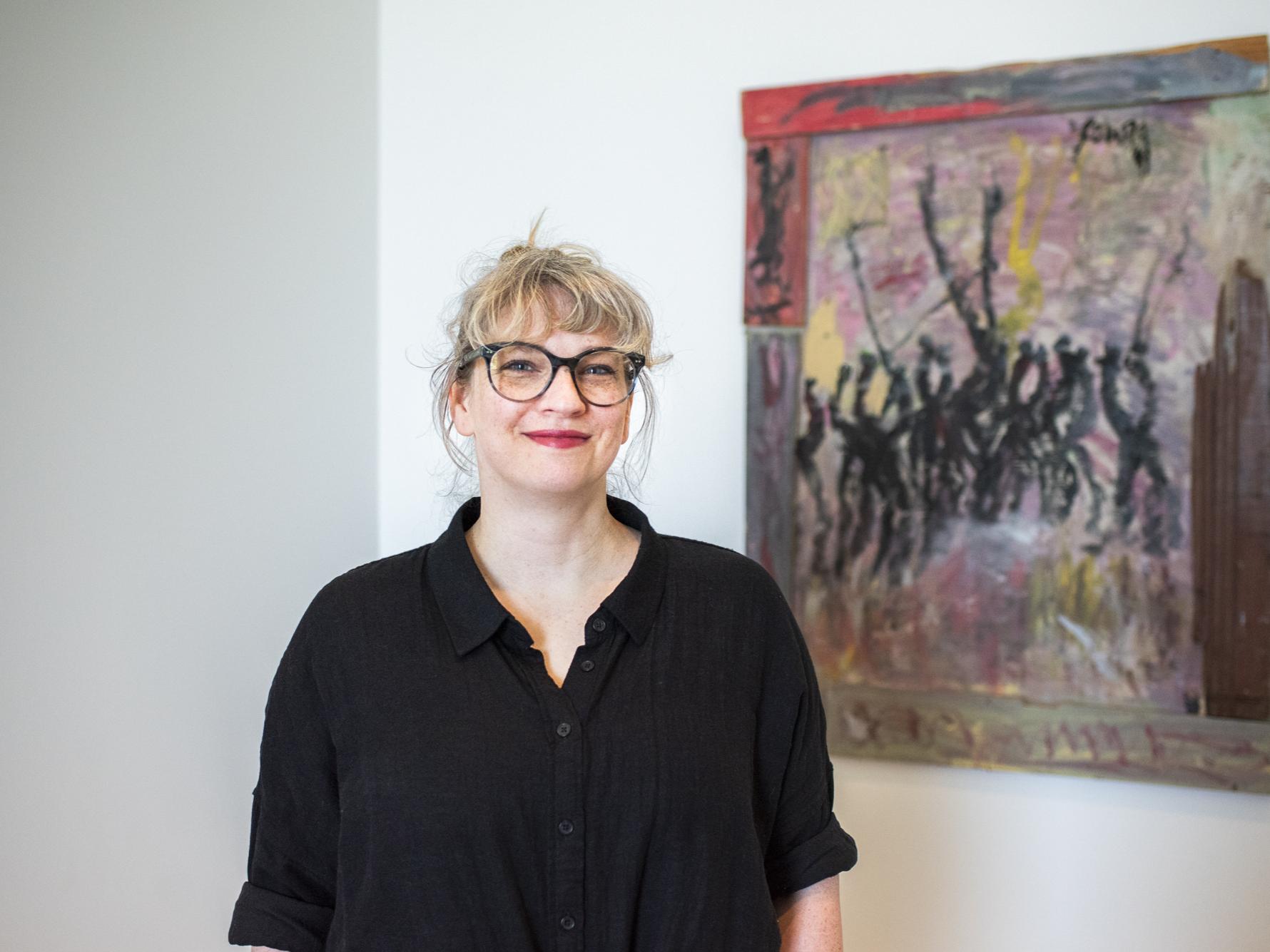 Photo of a woman in front of an artwork