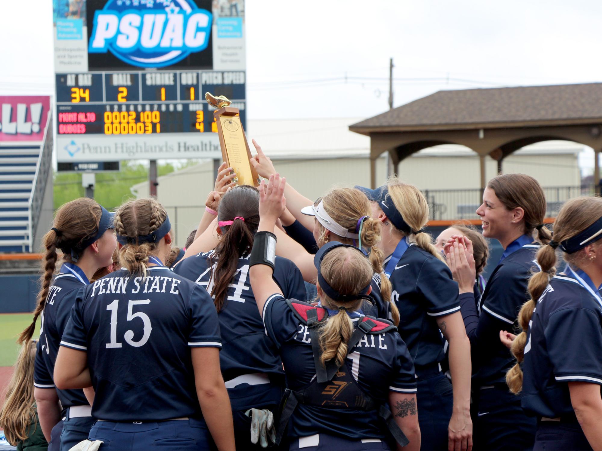 Members of the Penn State DuBois softball team gather and celebrate with the conference championship trophy after winning the championship at Heindl Field on May 4. This marked the first time in program history that the team secured the conference championship.