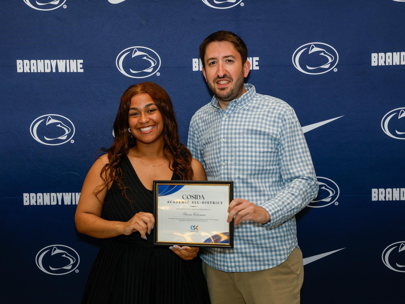 student and staff holding certificate