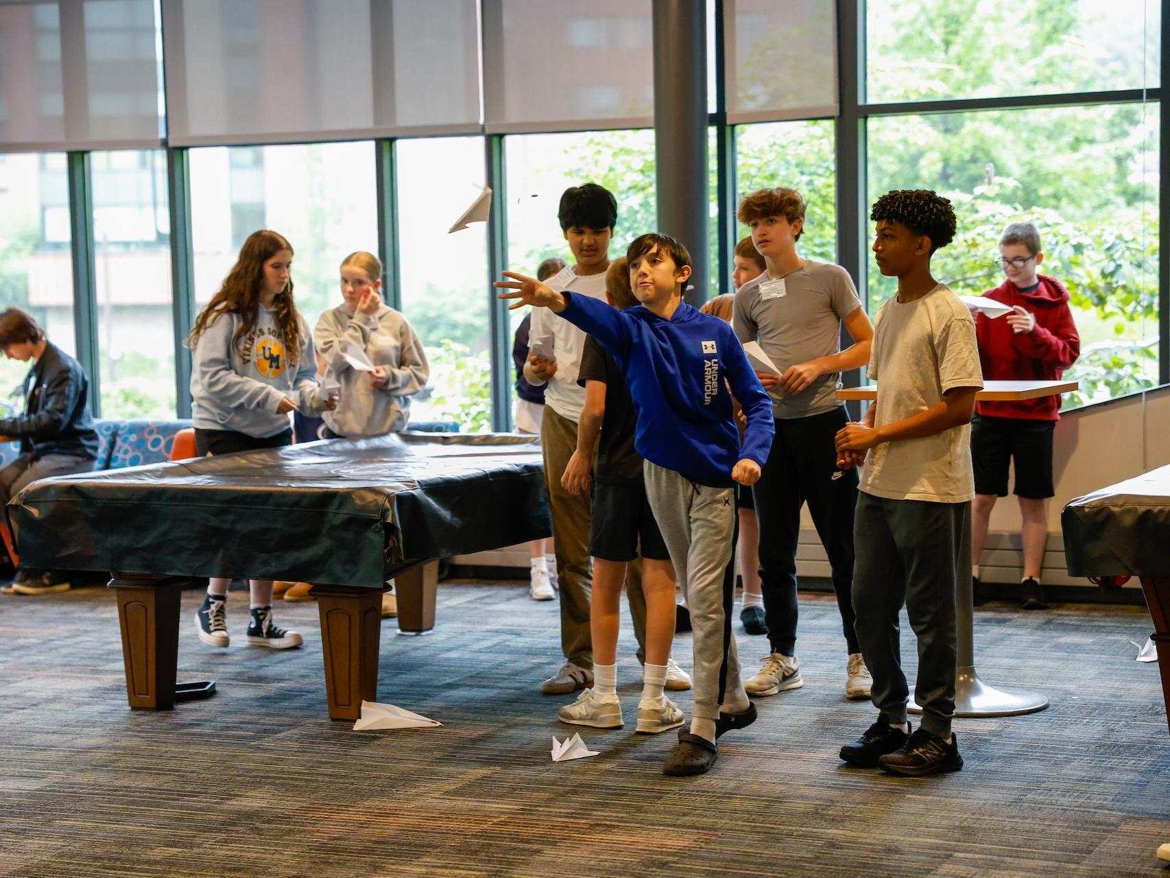 students flying paper airplanes