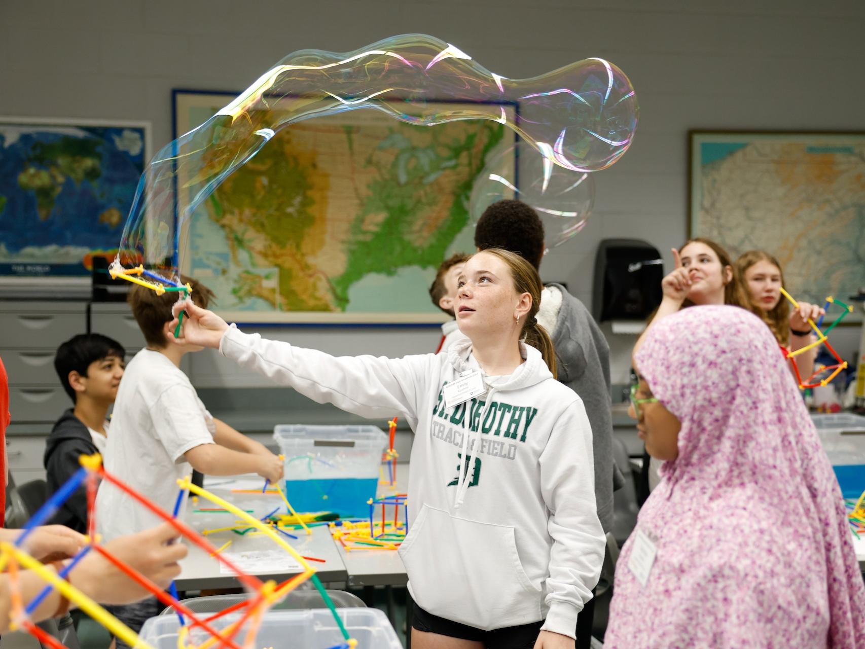 student waving bubble wand