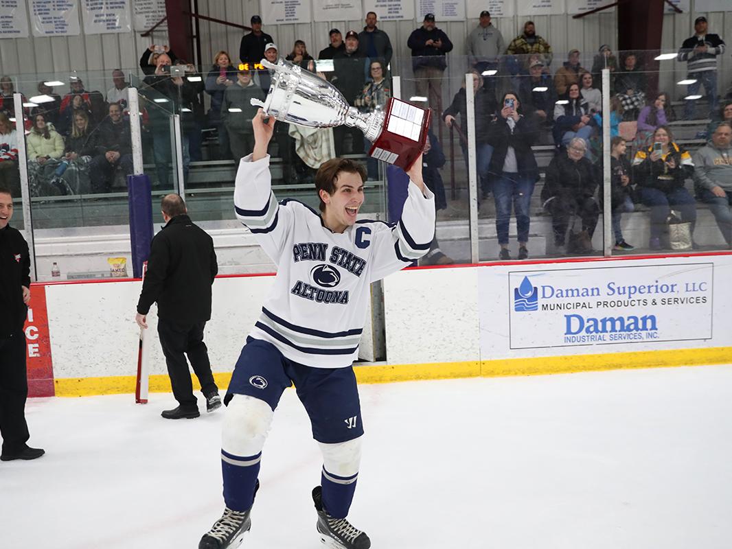 Team captain Christian Strang raises the College Hockey East trophy after the championship game against Robert Morris University in February. 