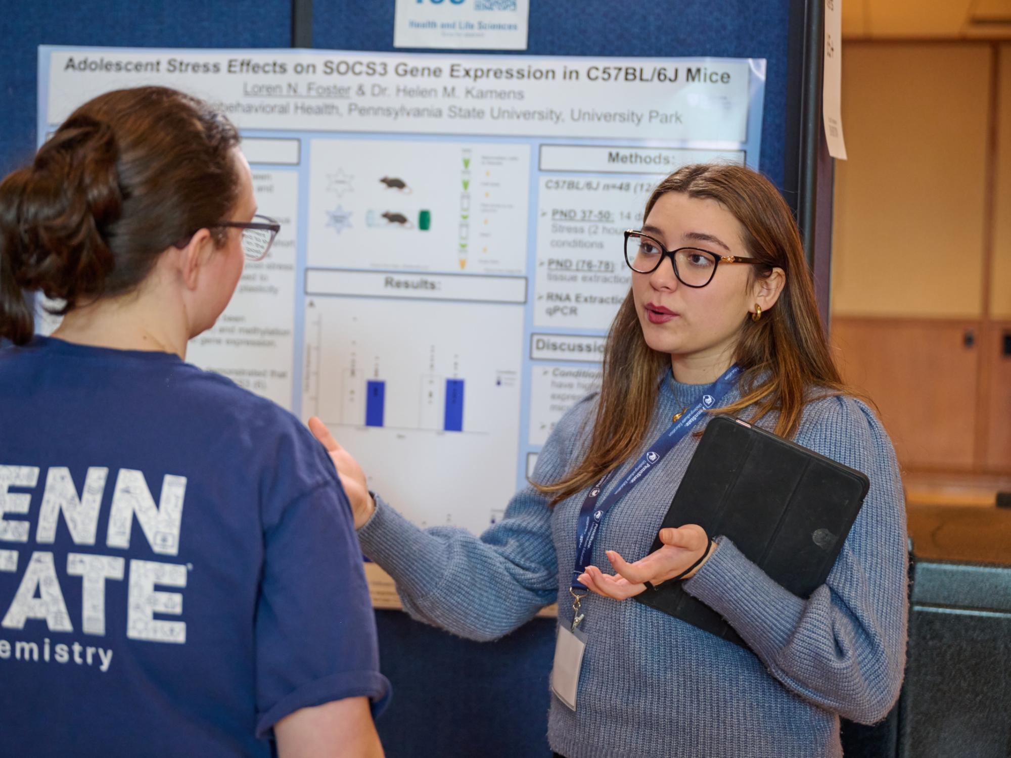 Loren Foster presenting research poster to judge