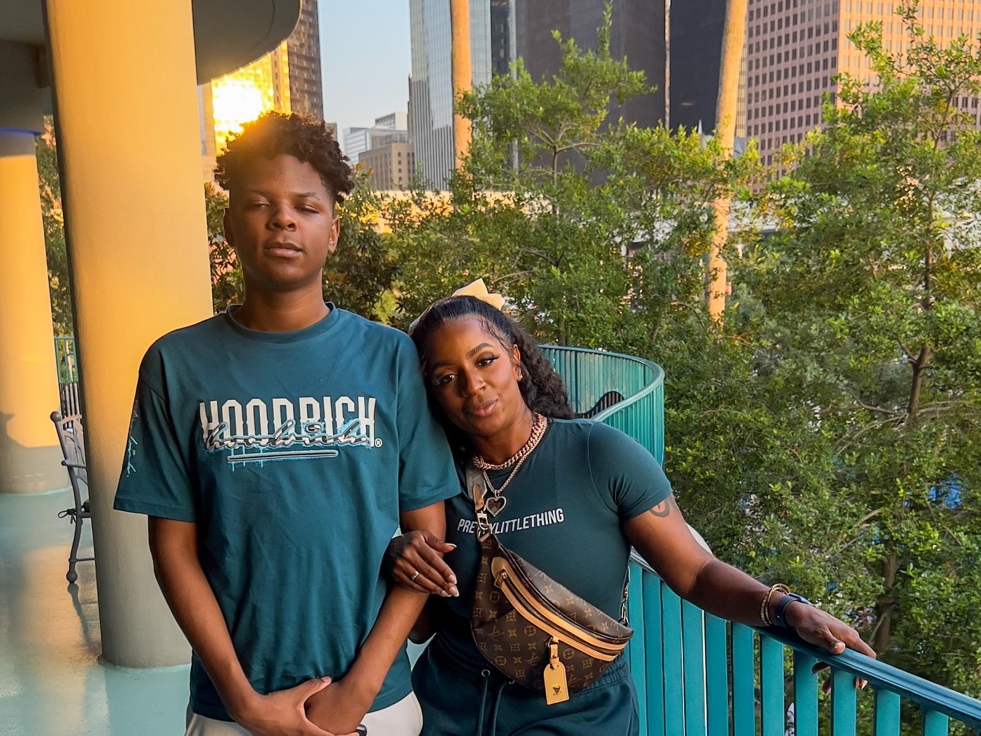 Felicia Ellis-Jones (right) stands next to her son (left) in front of trees and skyscrapers.