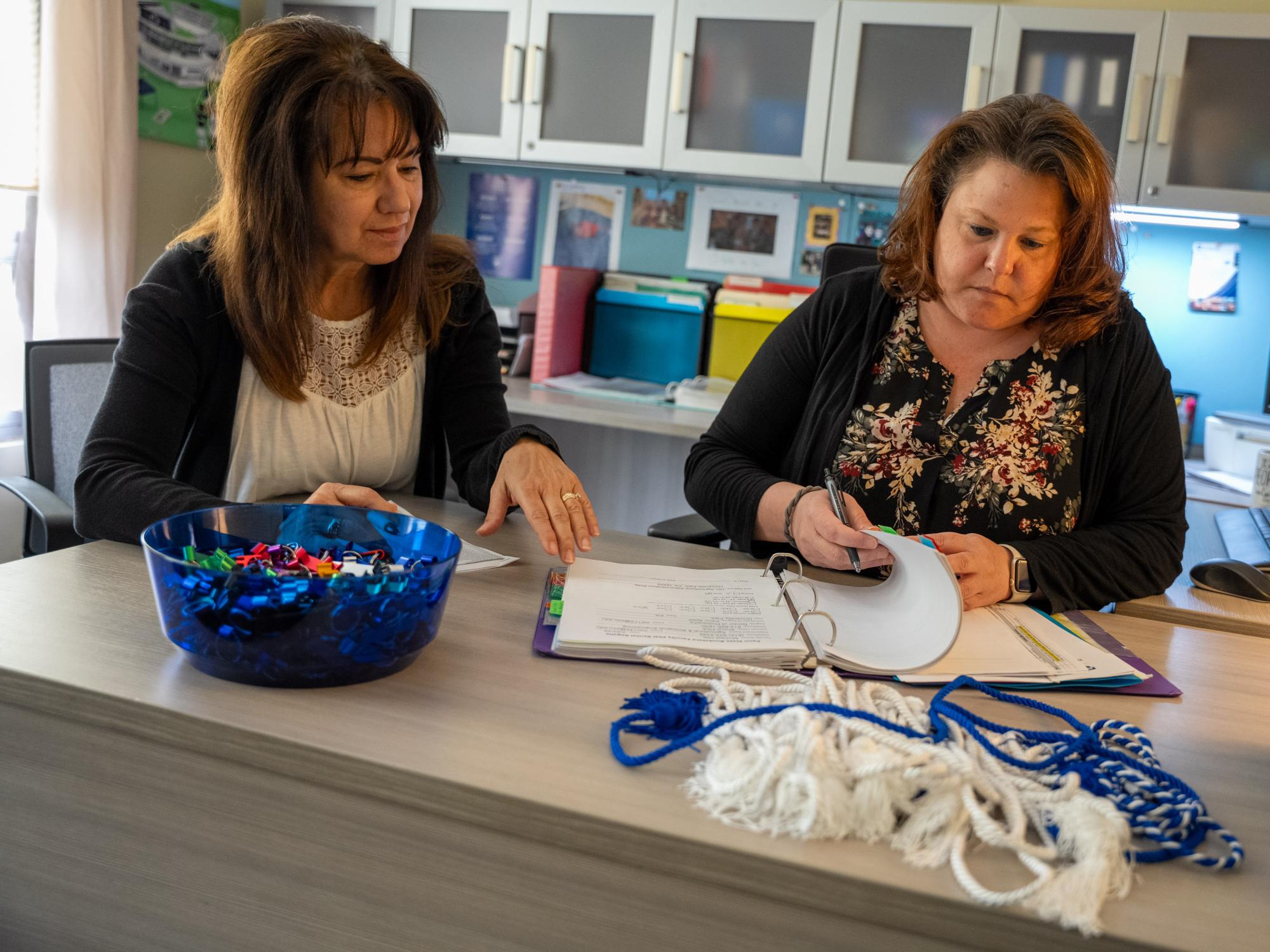 Two women look over paperwork at a desk