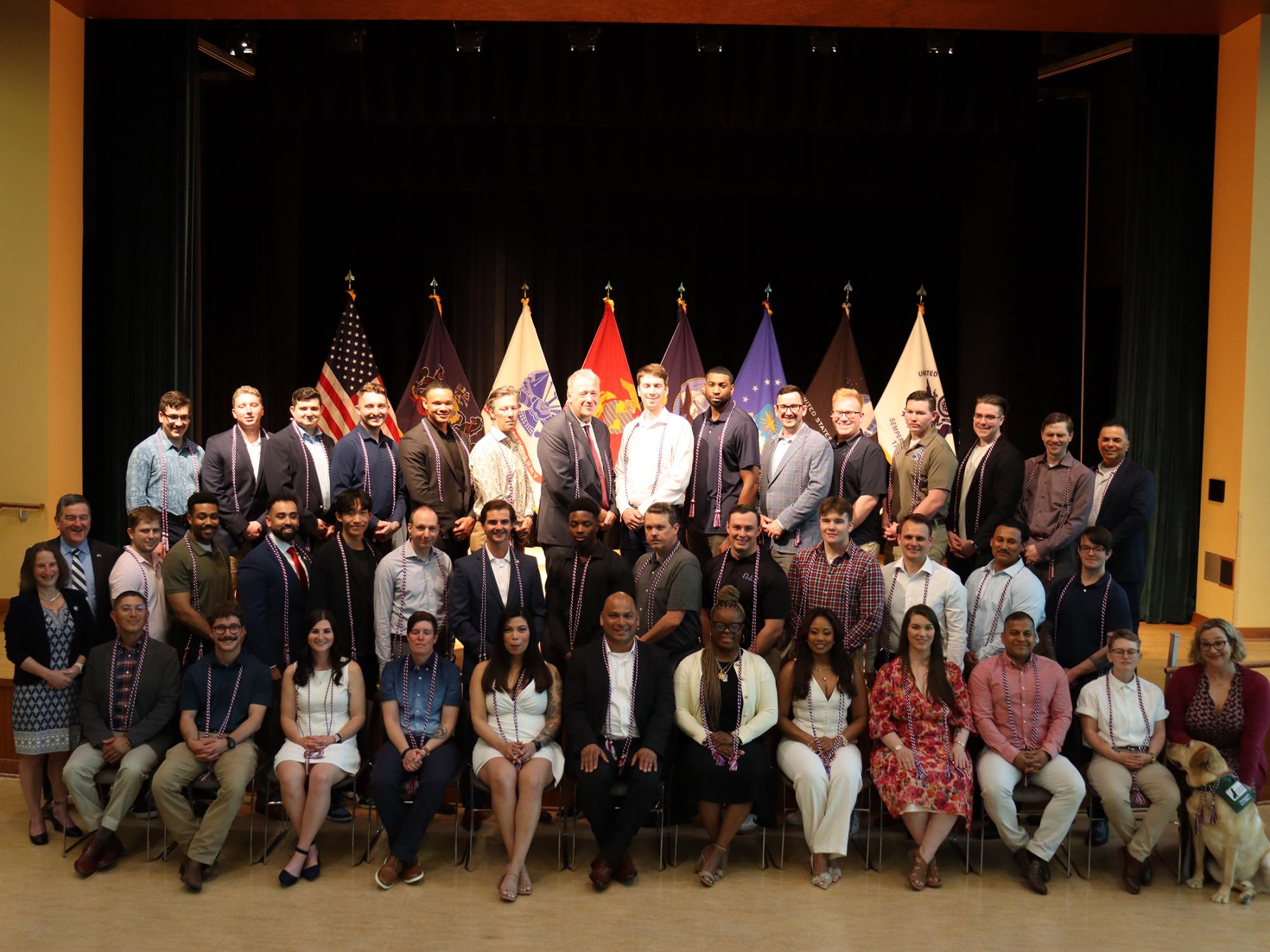 A large group of people posing for a photo on a stage.