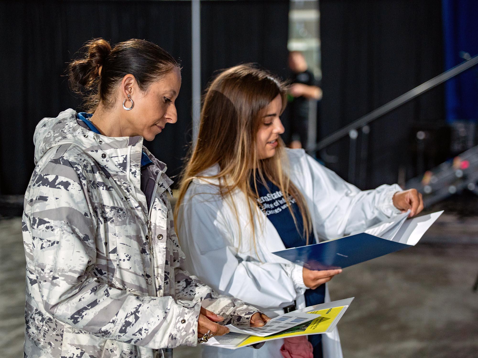 Two women look over a sheet of paper in an event space