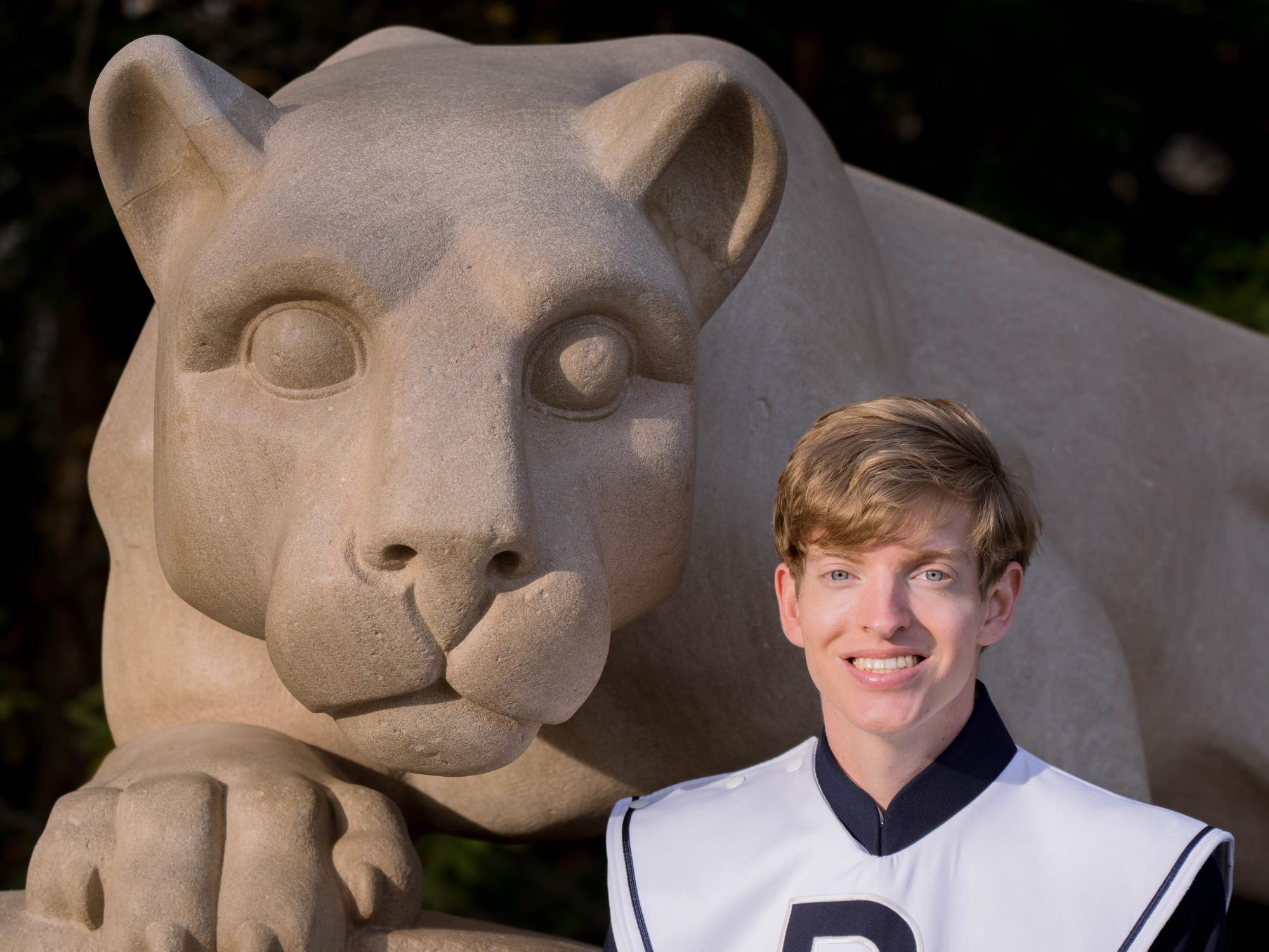 Noel in front of the lion in his Blue Band Uniform.