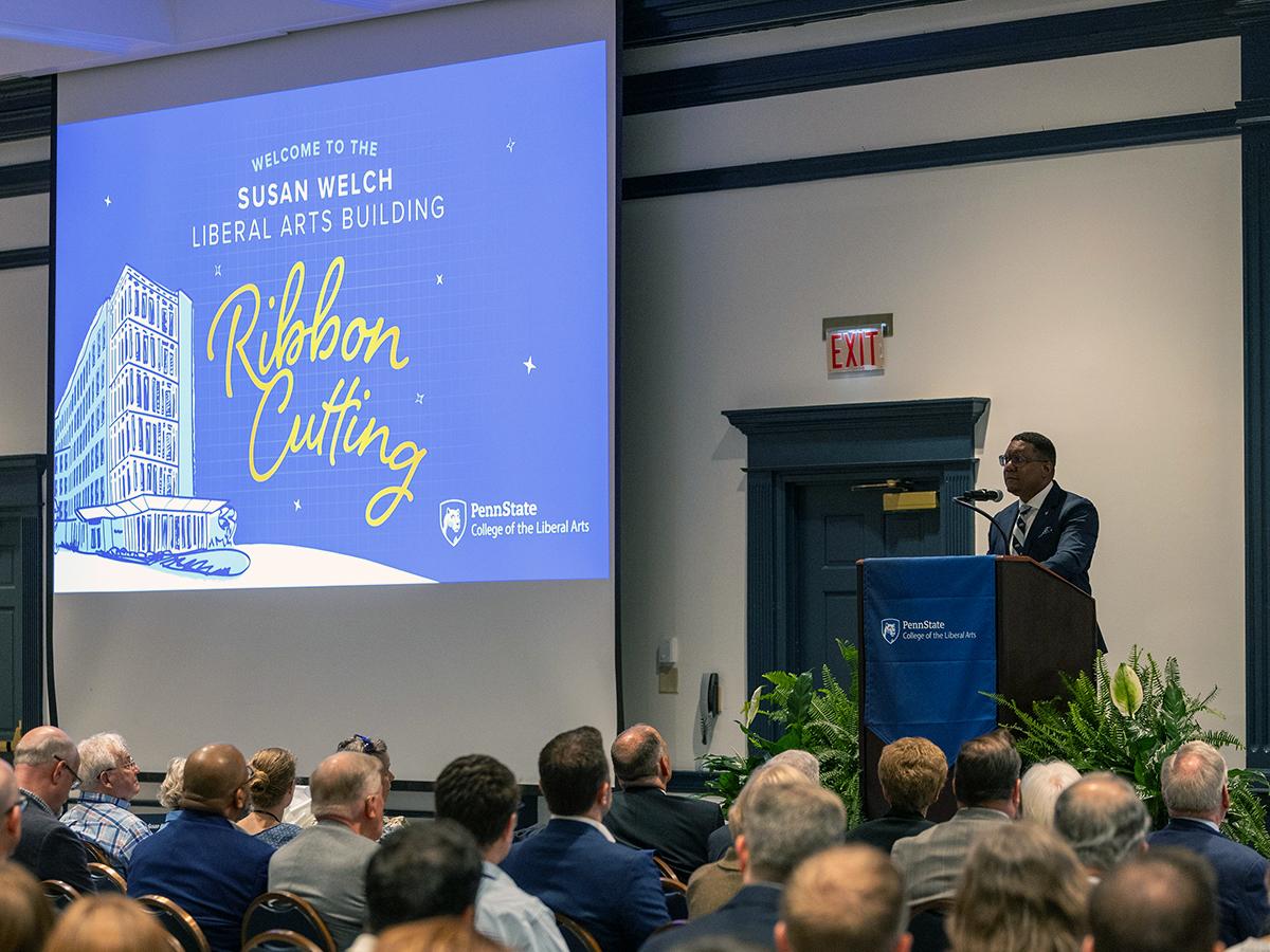 Clarence Lang stands at  podium and delivers remarks to audience at Welch Building ribbon cutting