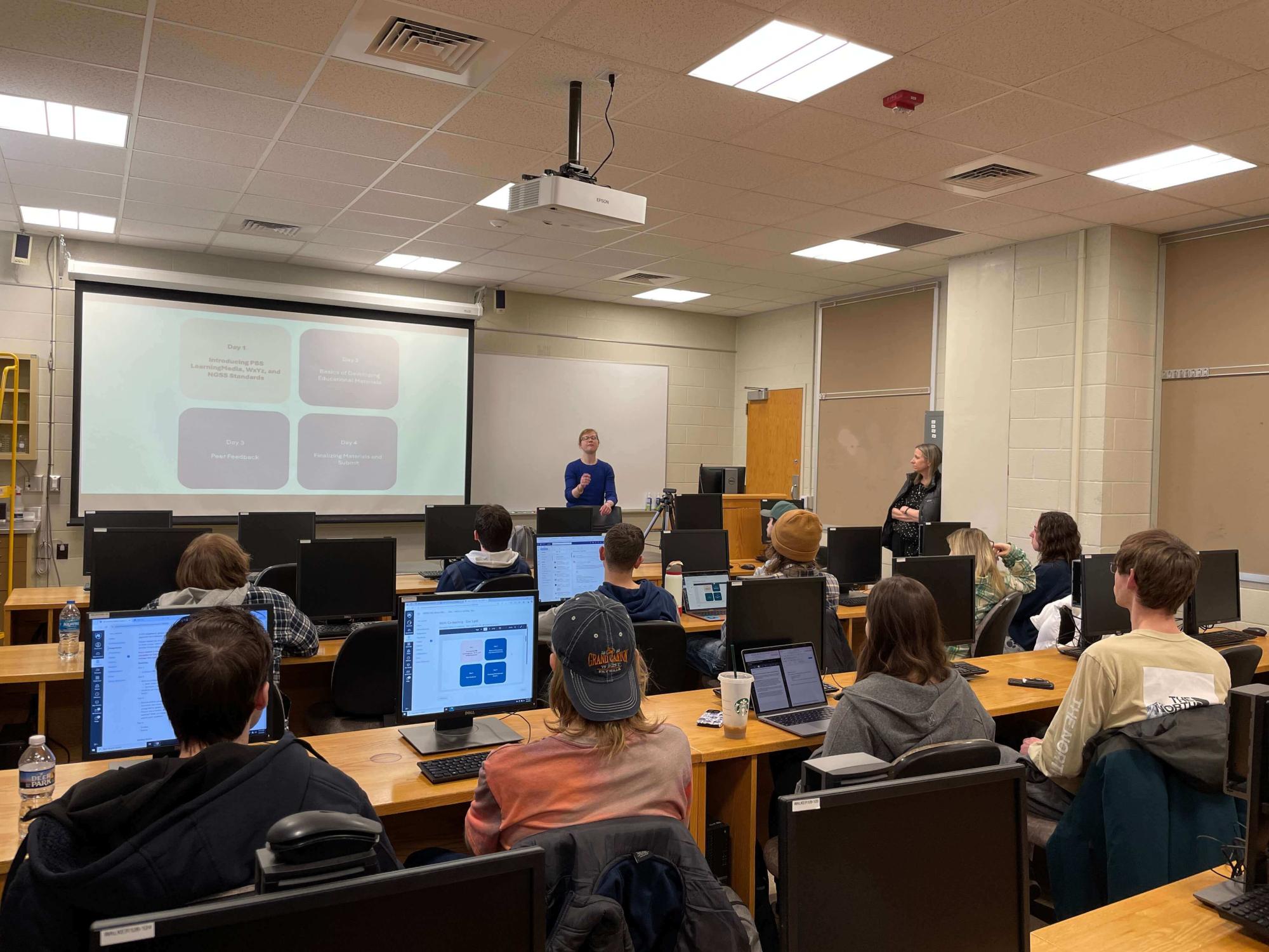 Instructor standing at a podium in front of a classroom of students.