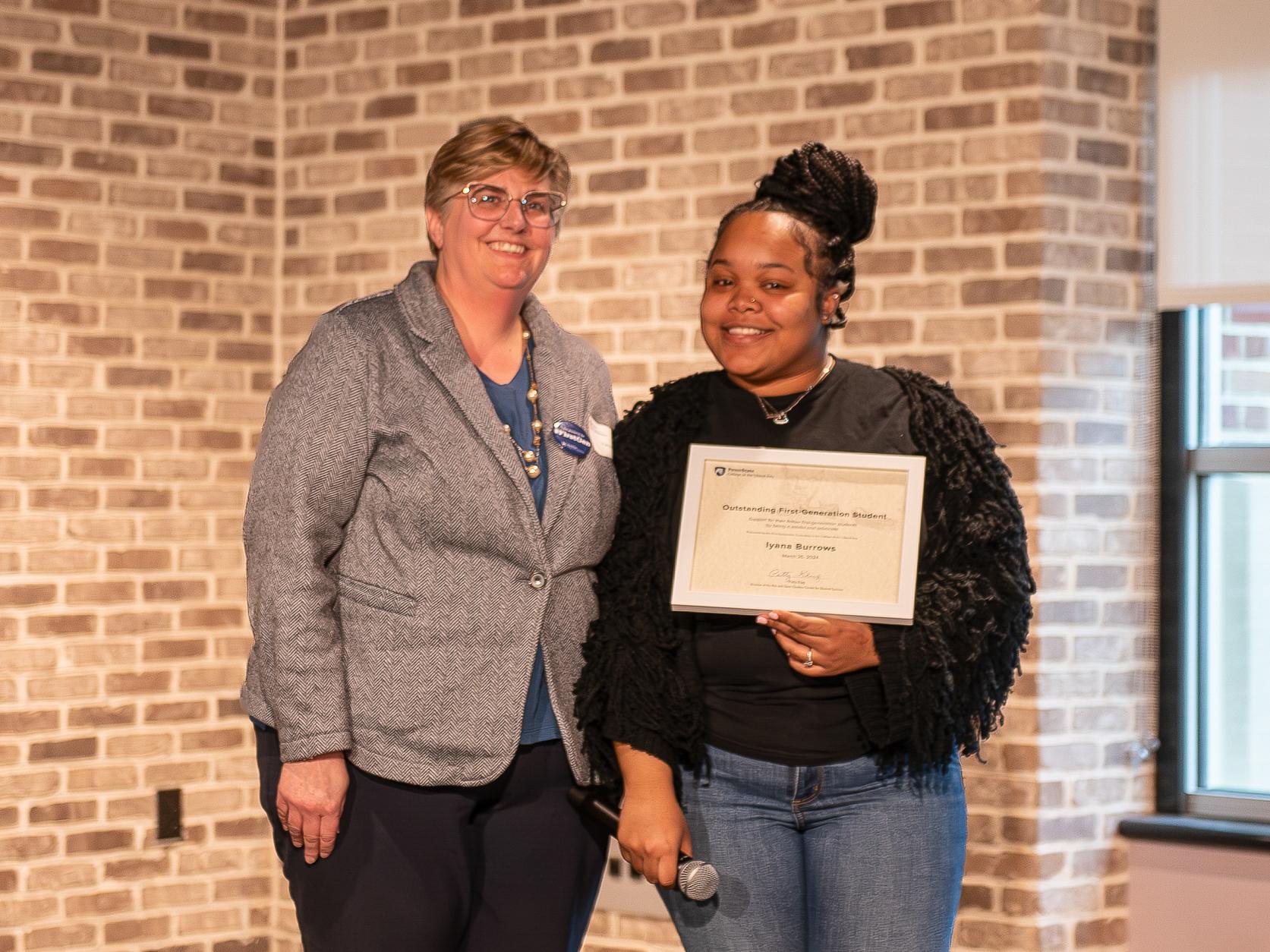 Iyana Burrows holds certificate while standing next to Patty Klug.