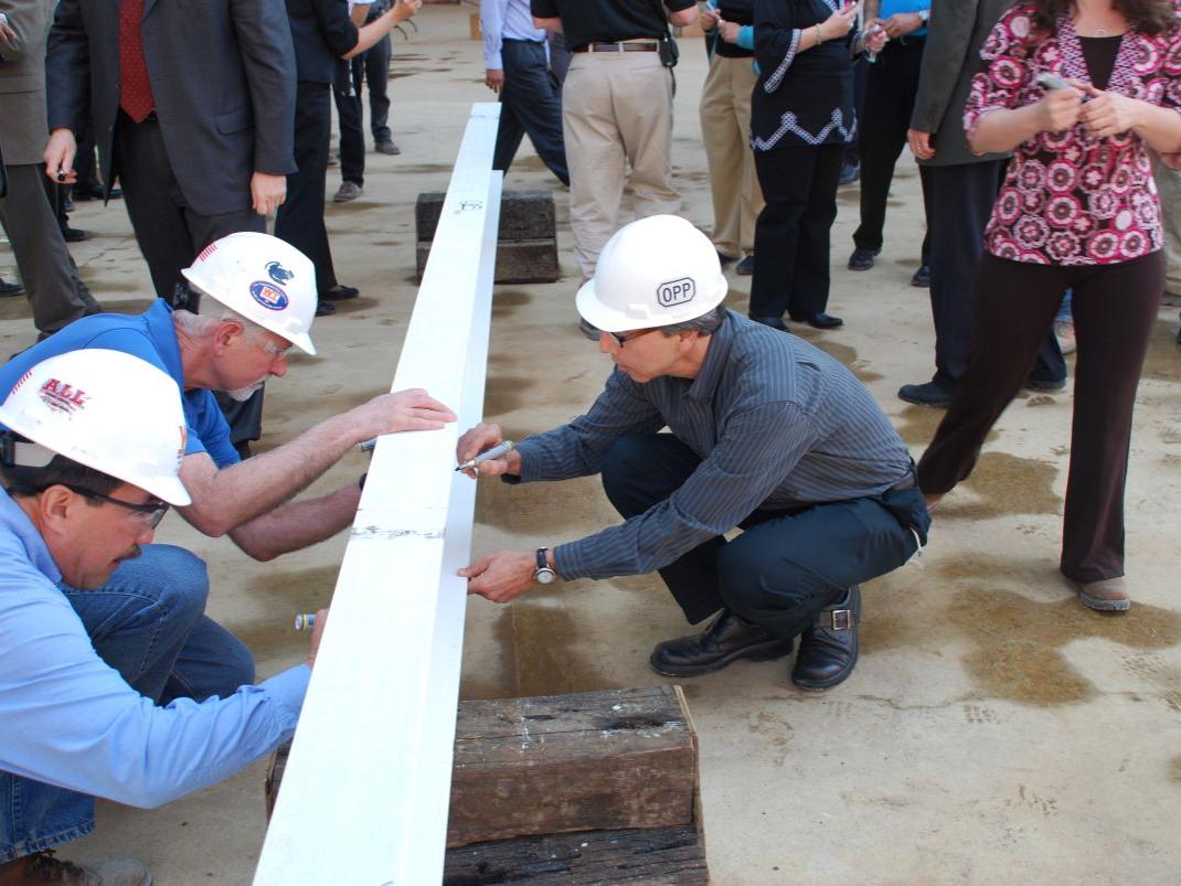 Man signing a beam at a construction site 