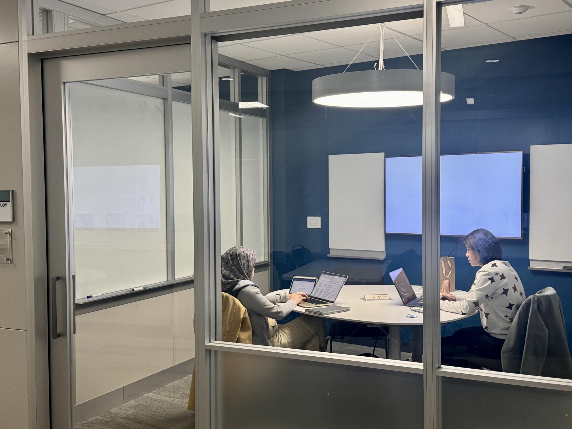 Two female students working in a Pattee Library small group study room