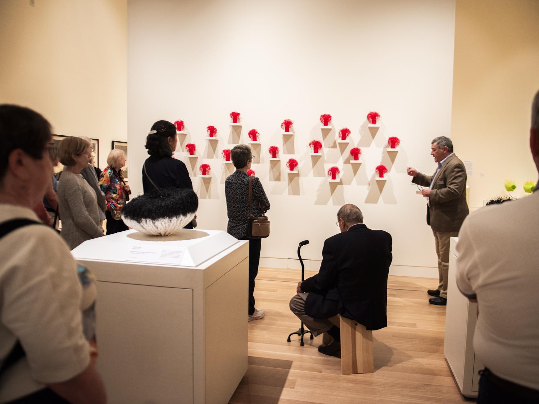 A man giving a lecture to visitors in an art gallery