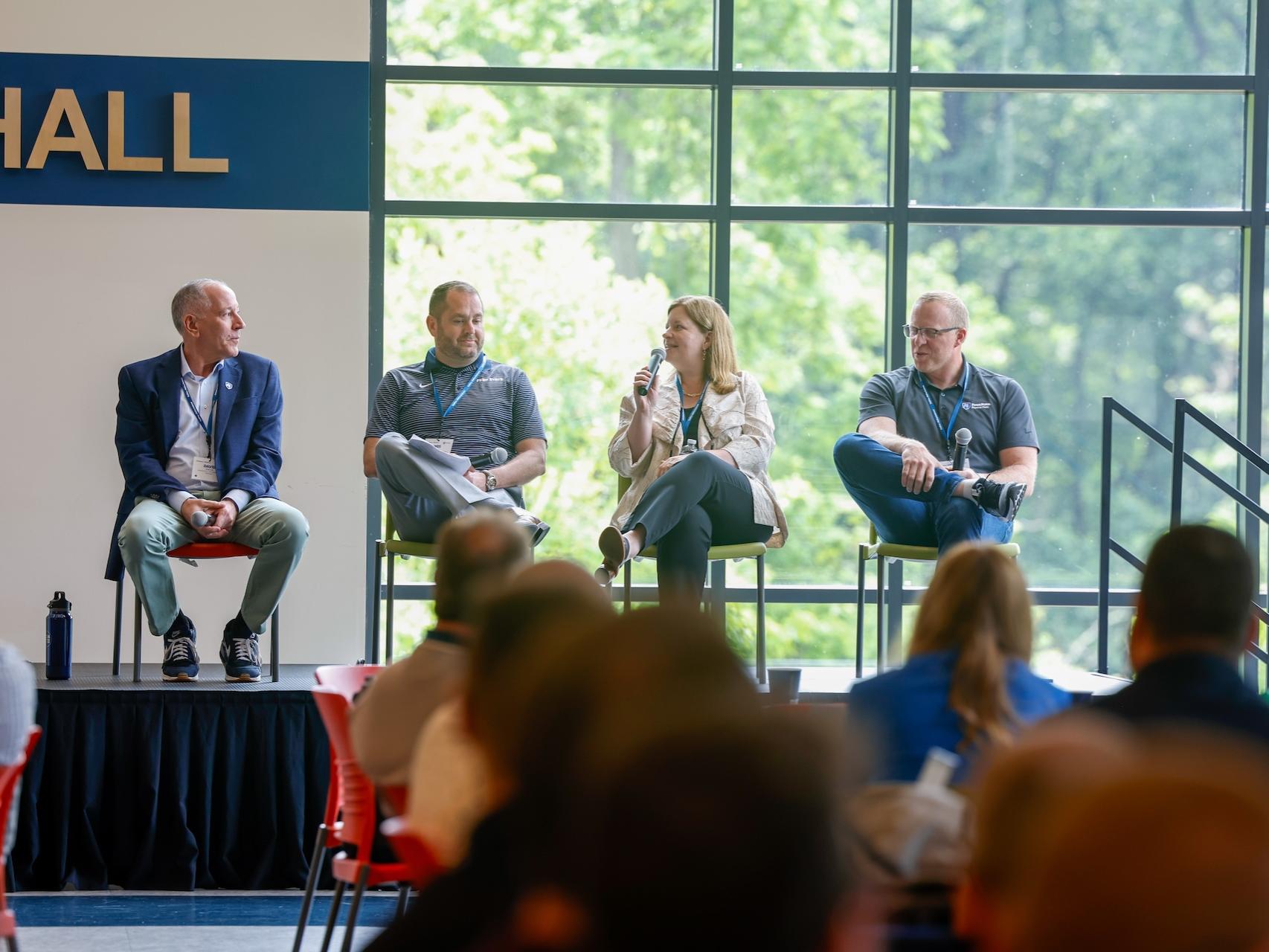people sitting on a panel on stage