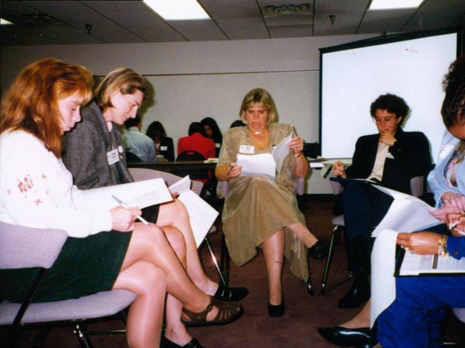 A small group of people in a half circle working on a project.
