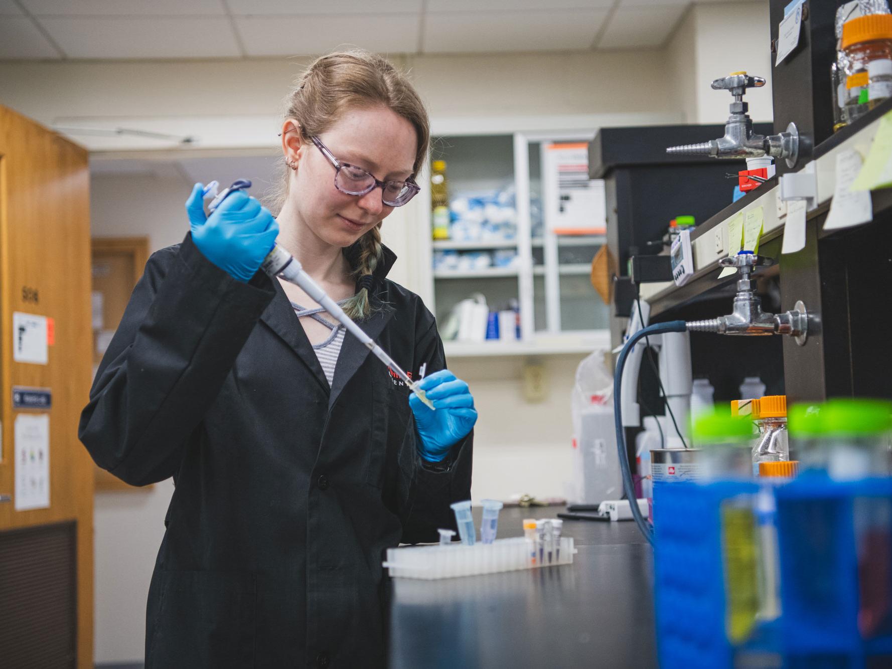 Lauren Bellfy pipettes material in the lab
