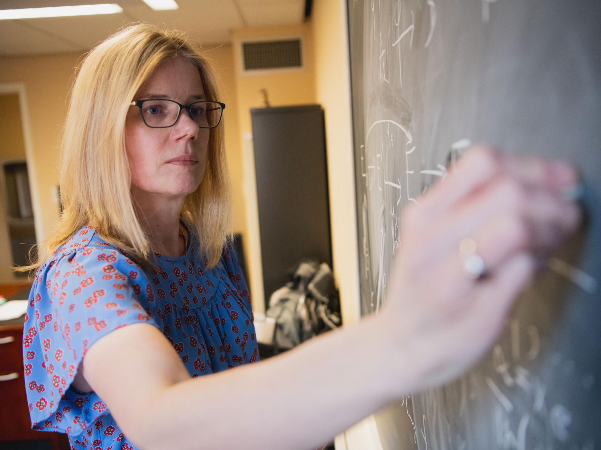 Kirsten Eisenträger writes on chalkboard