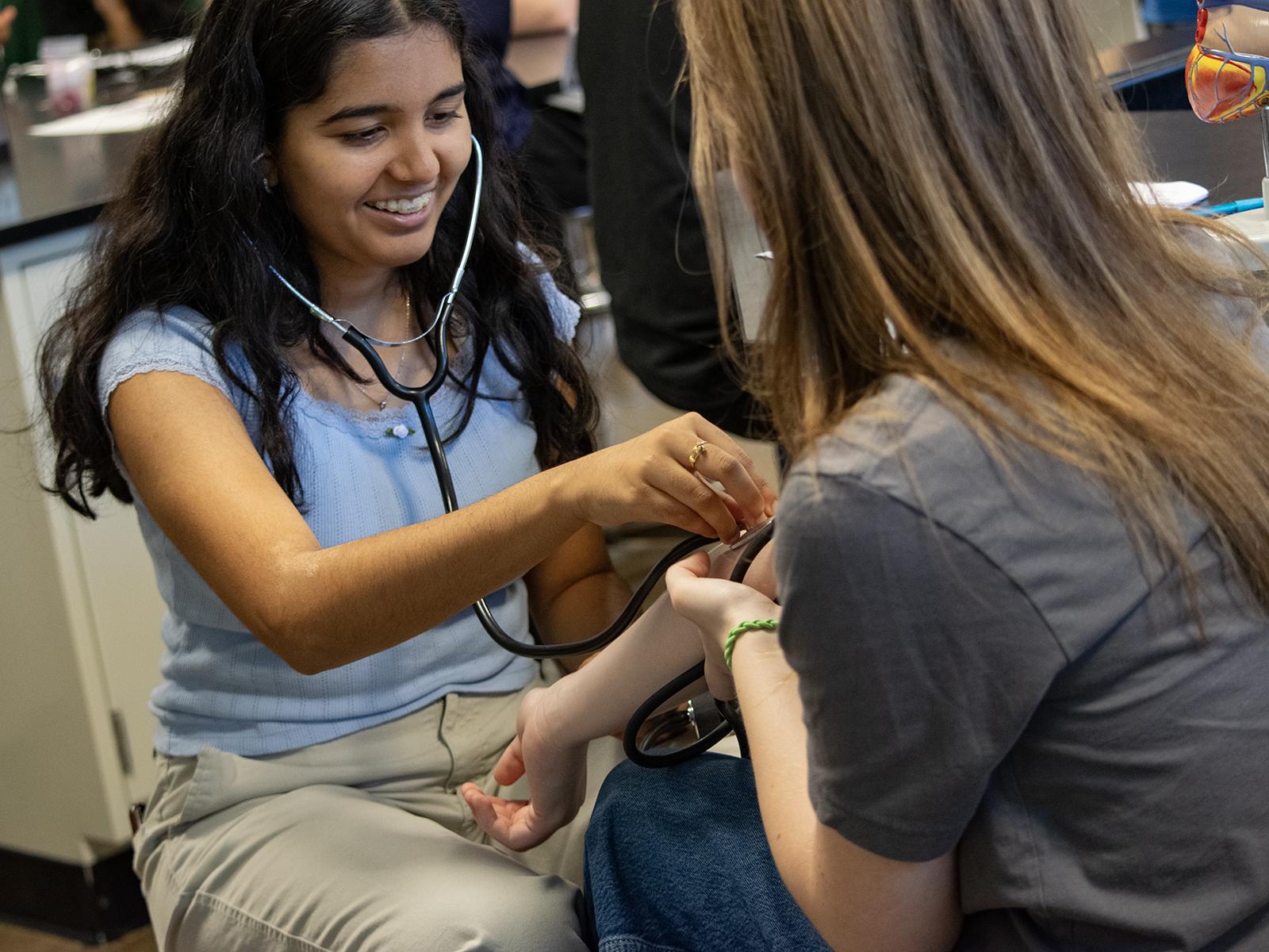 High School students listen with stethoscopes during an activity