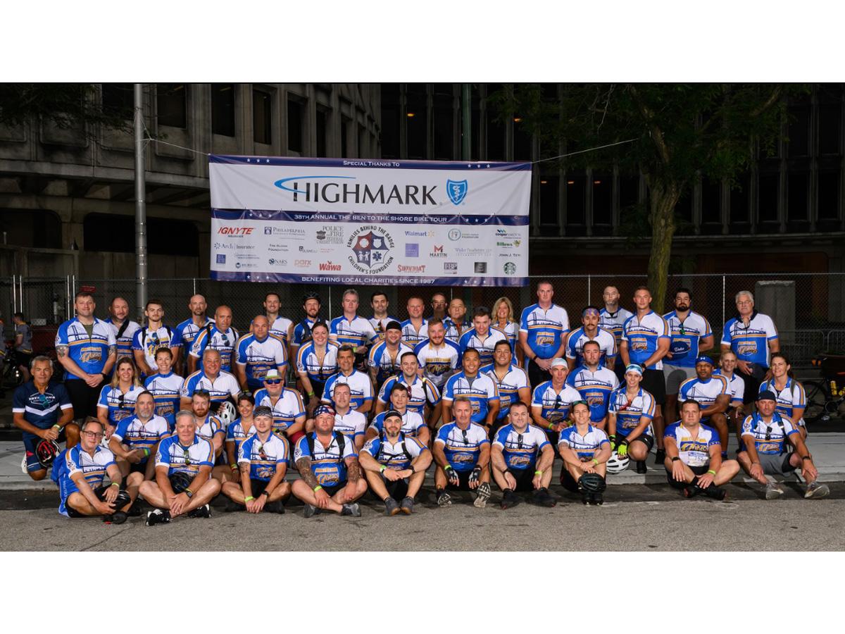 Delco 476ers team posing for photo in front of sign displaying sponsors