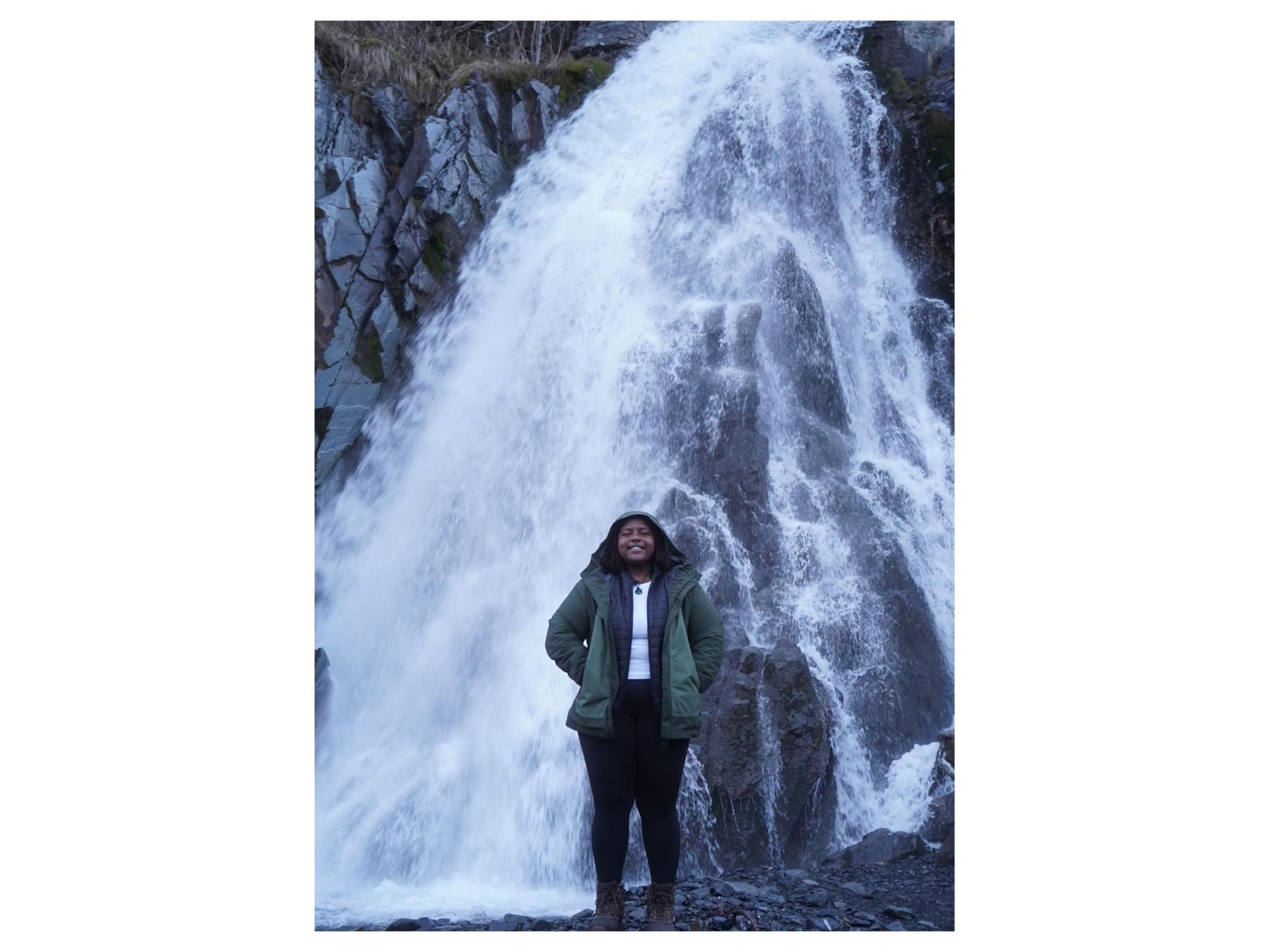 person stands in front of waterfall