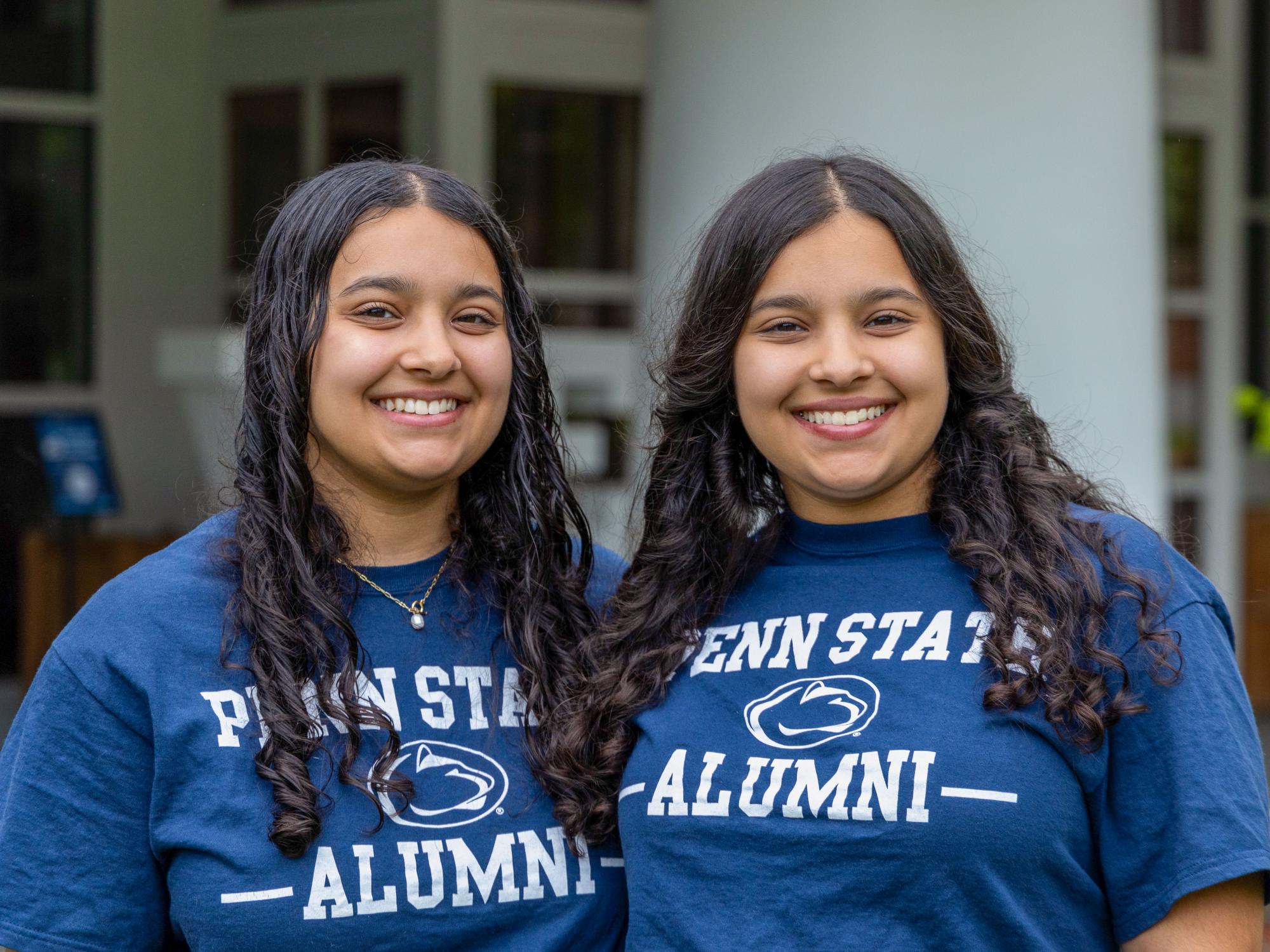 Abby (left) and Olivia Kayani stand in matching “Penn State Alumni” T-shirts outside the Hintz Family Alumni Center.