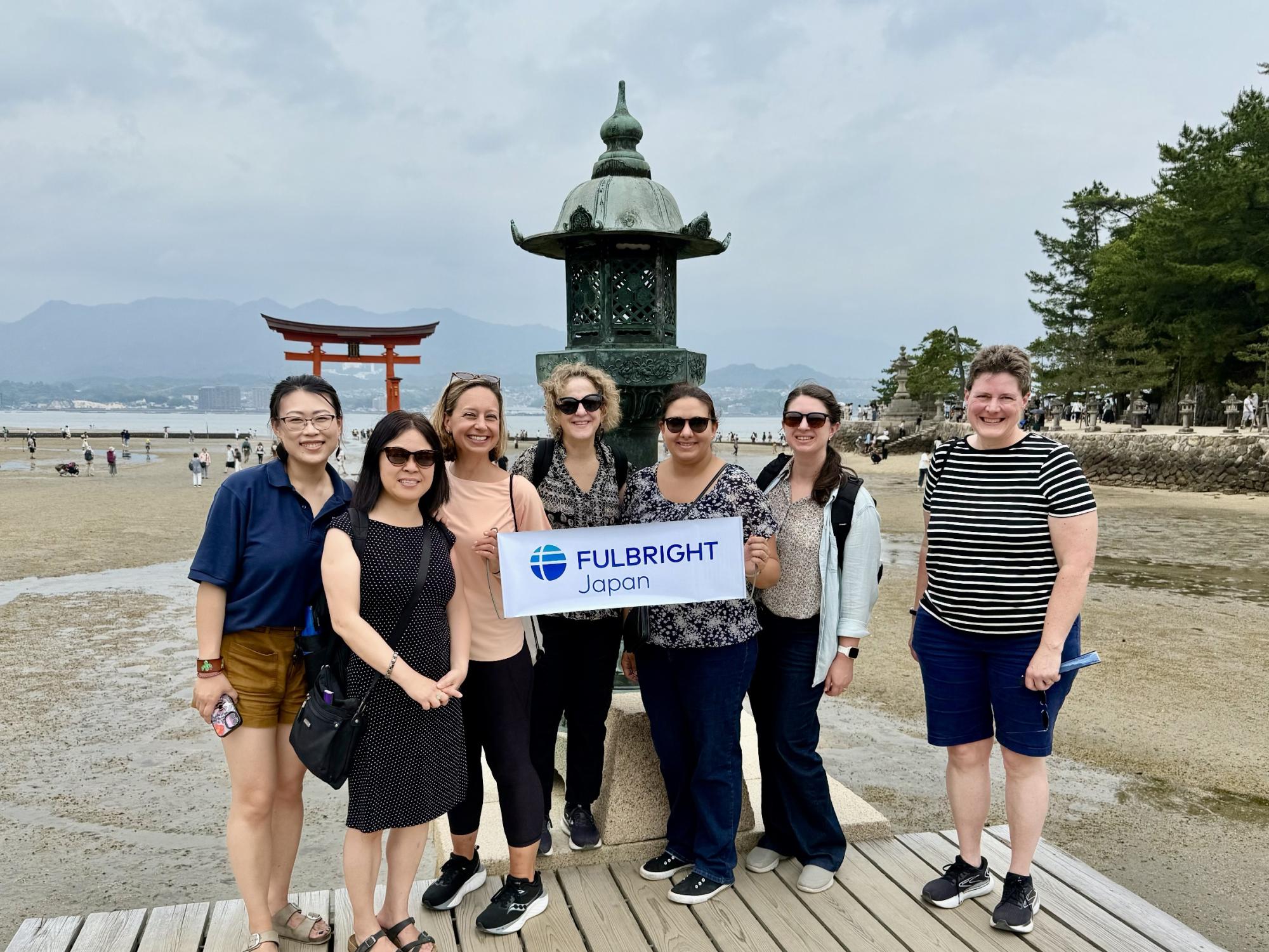 A group of seven people at a monument at Hiroshima