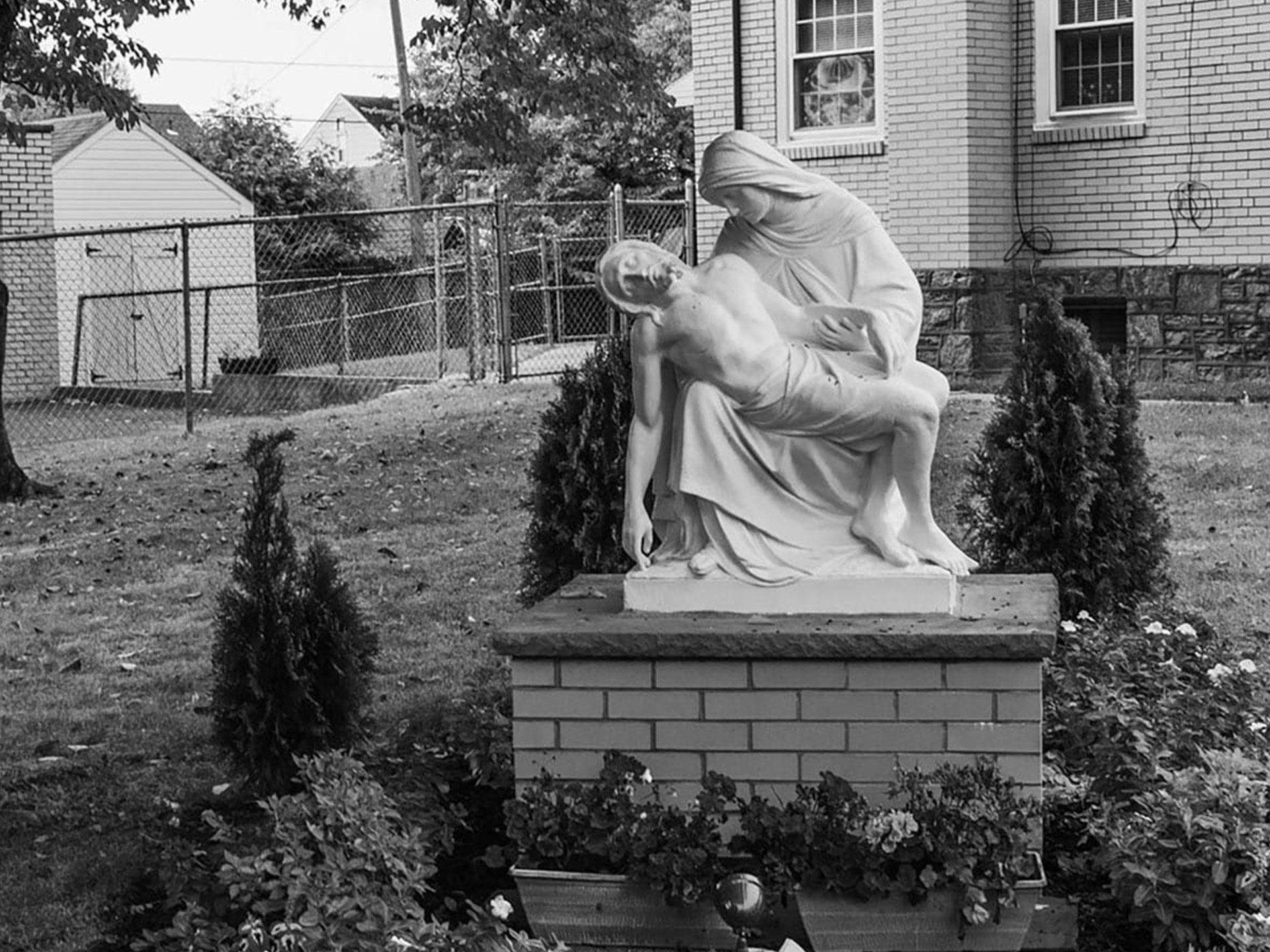 Black and white image of marble statue depicting religious figures