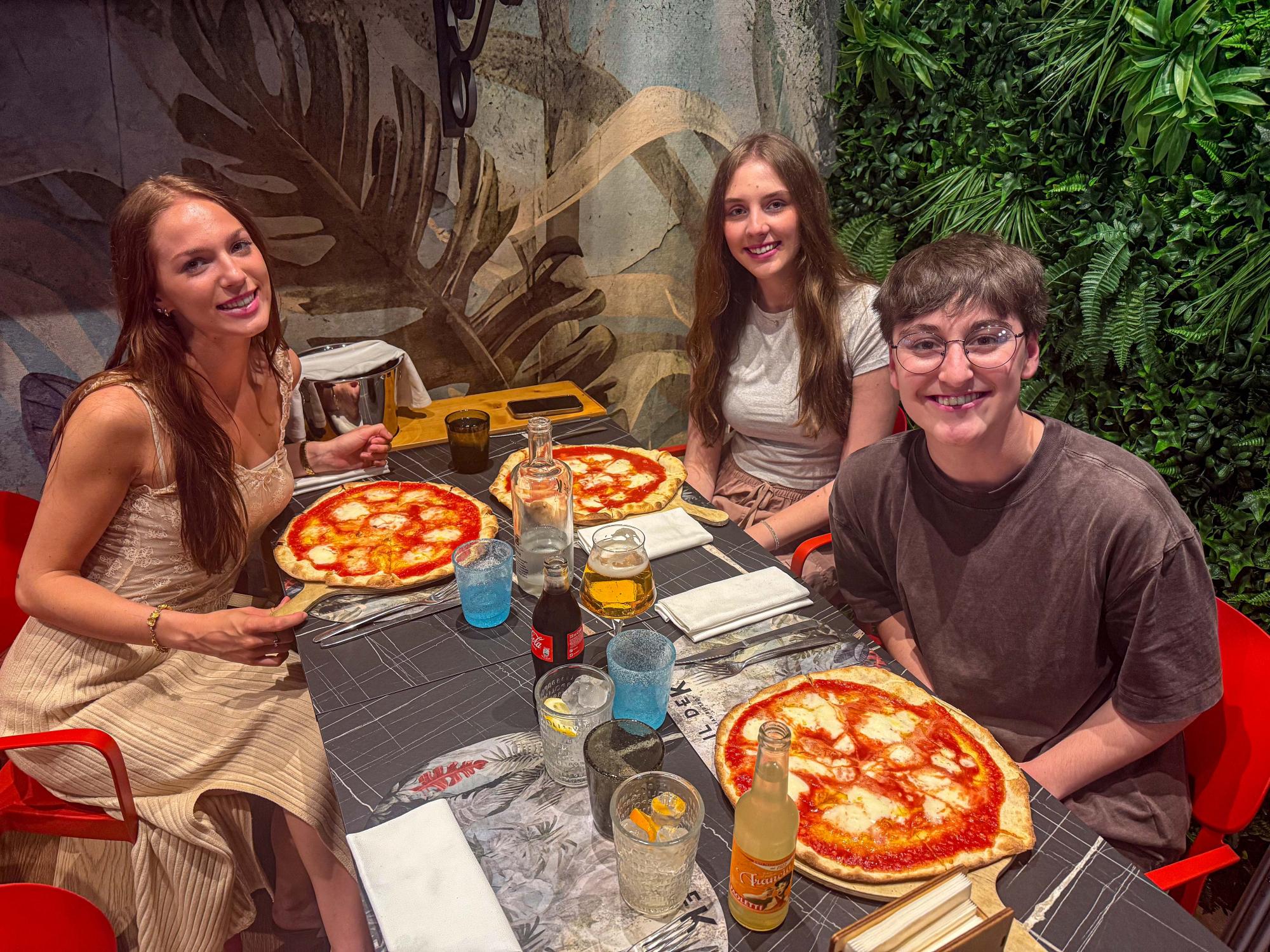 Alexis Wilson (left), Madison Yeager (middle) and Livi Hepler (right) sit at a table ready to eat the pizza in front of them.