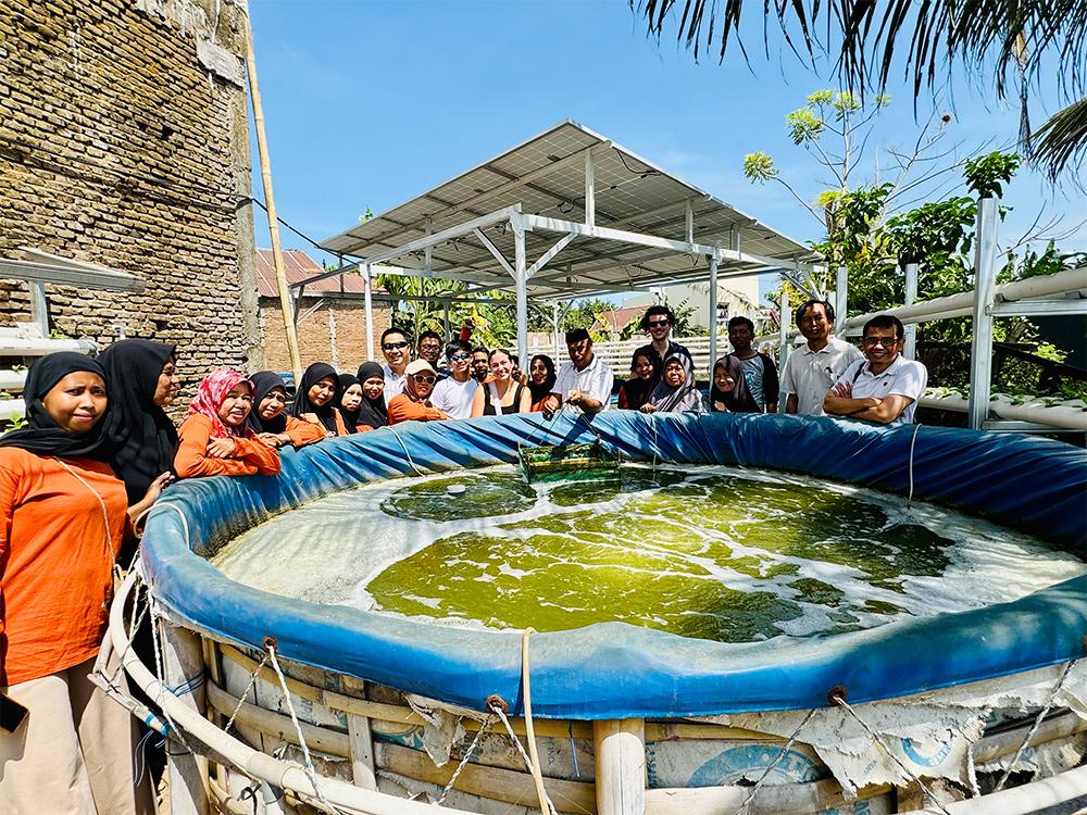 A group of people stand in front of a shrimp tank