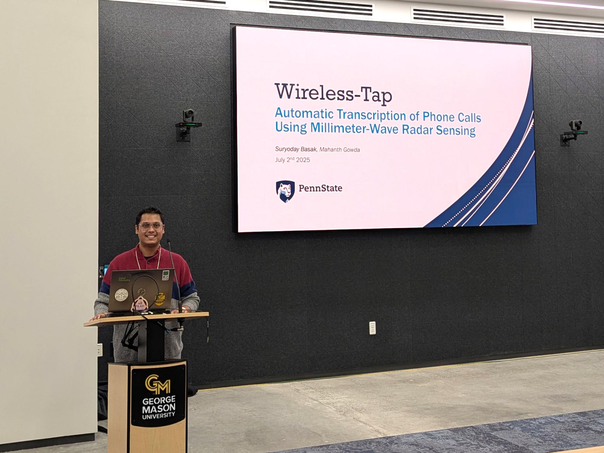 An individual stands at a podium in a classroom. 