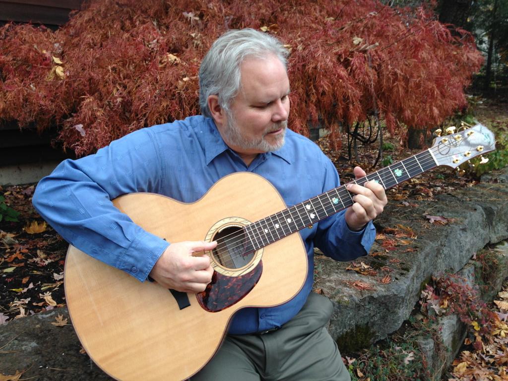 Emeritus Professor James  Herbert plays guitar.
