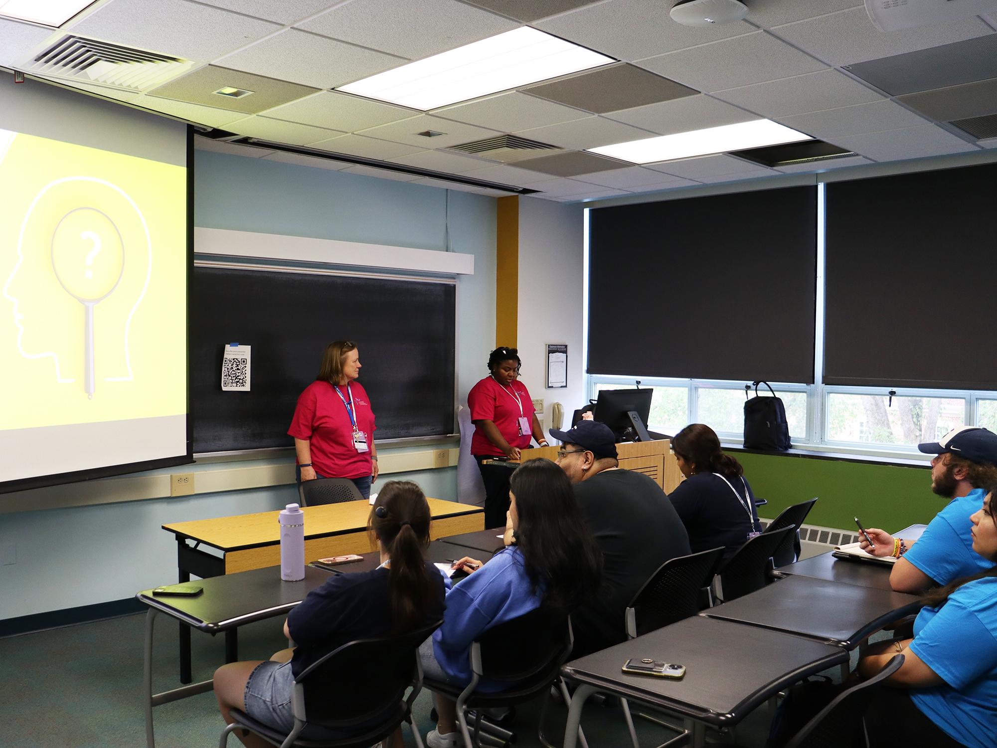 People present a PowerPoint in a classroom.